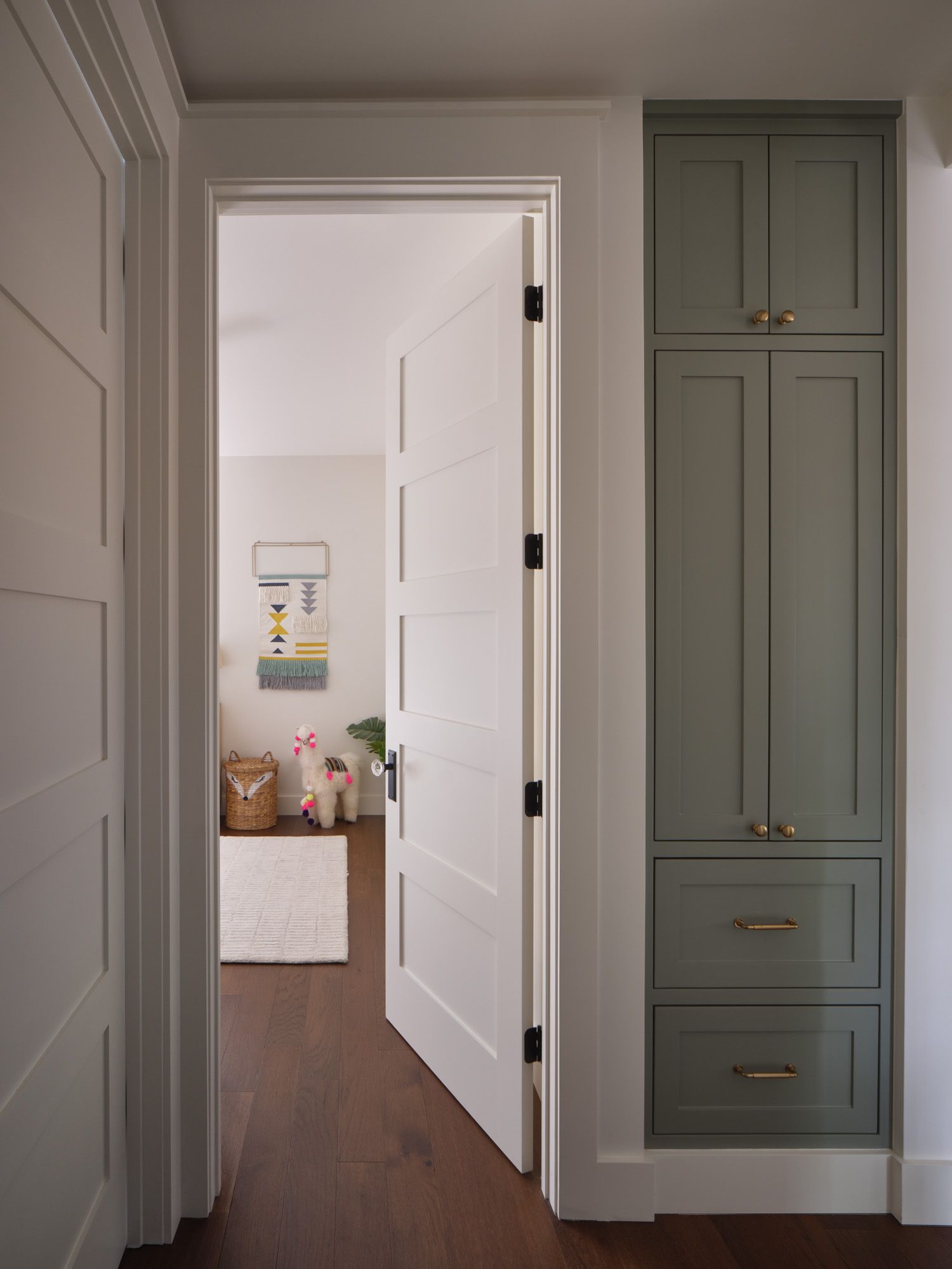 Open door beside built-in cabinets leads to a child's room
