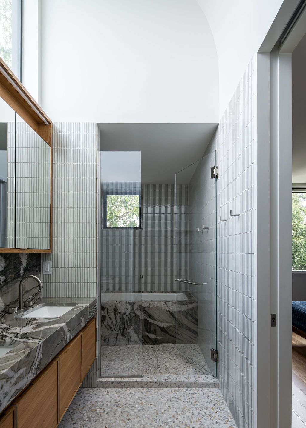 Bathroom with marble vanity, tiled shower and glass enclosure