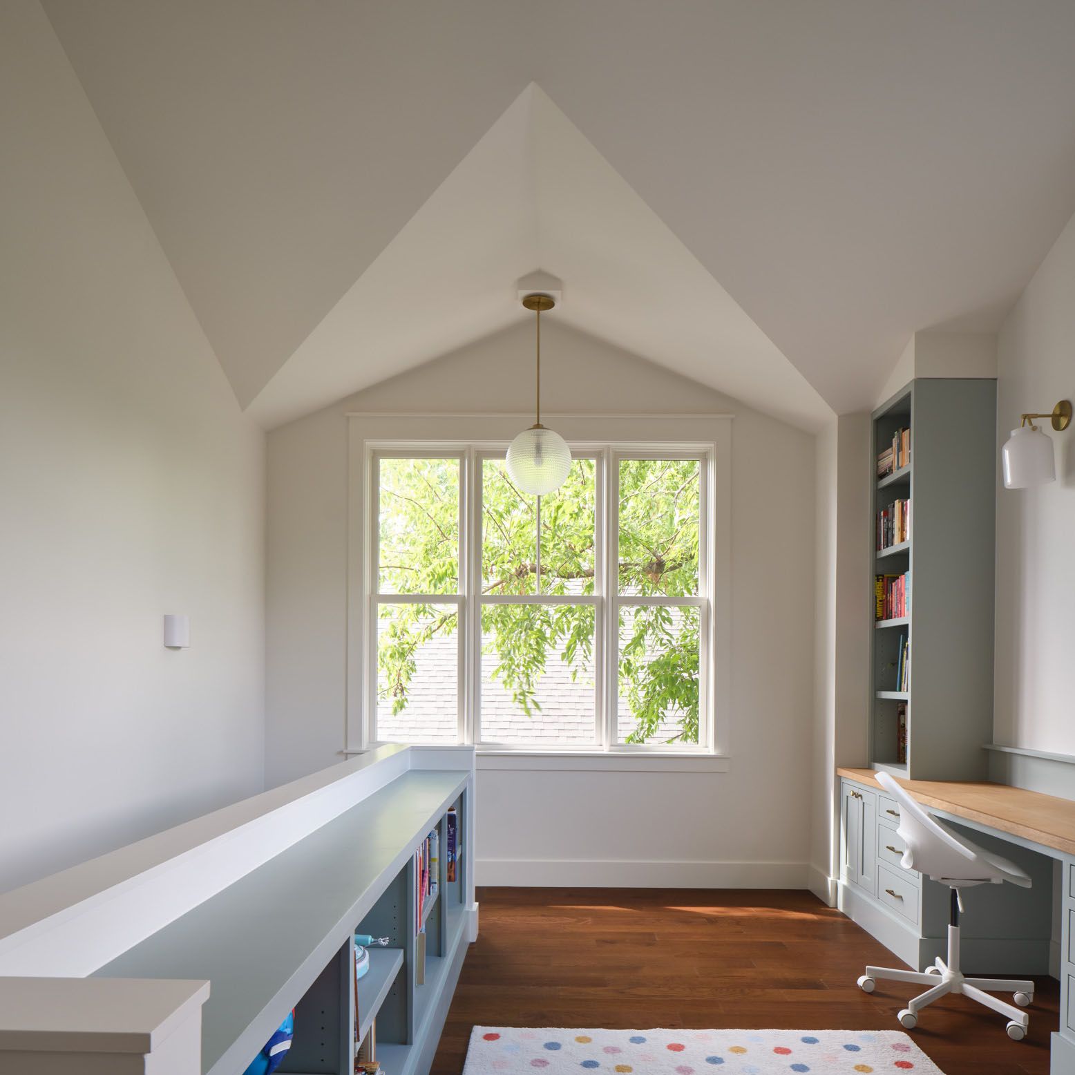 Home office with built-in desk, bookshelves and large window