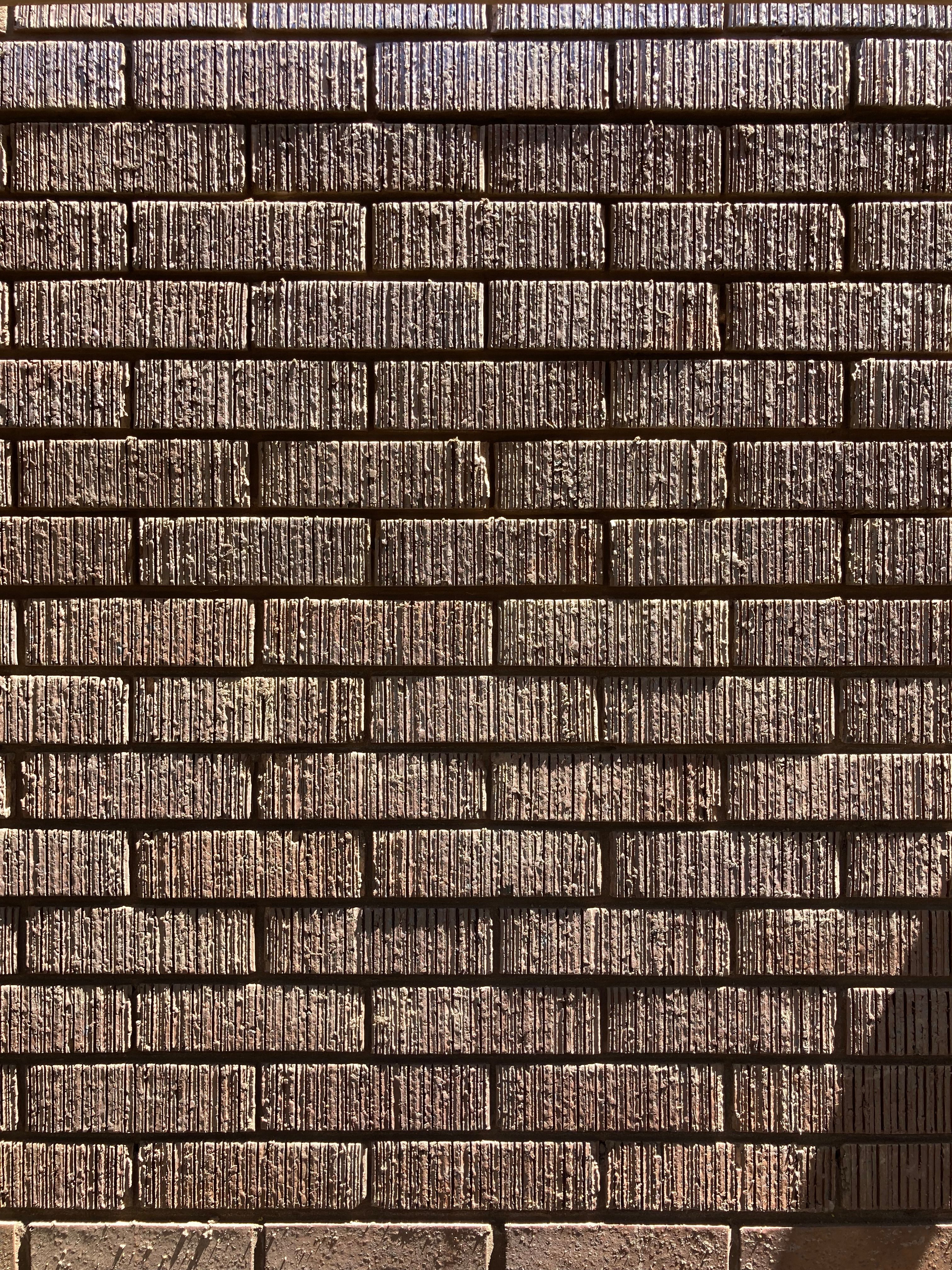 Textured brick wall with horizontal mortar lines