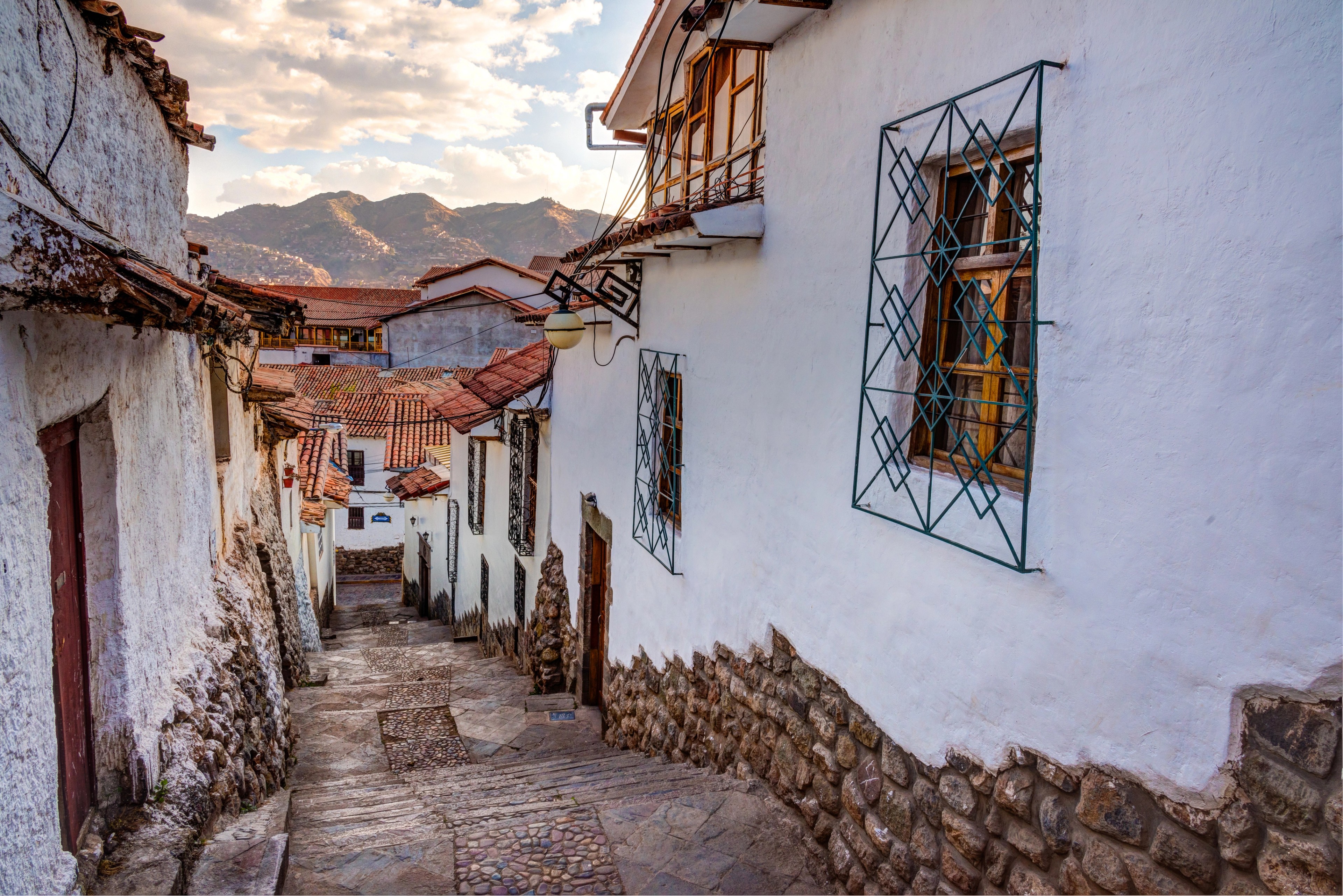 Cobbled street lined with whitewashed buildings and wooden balconies.