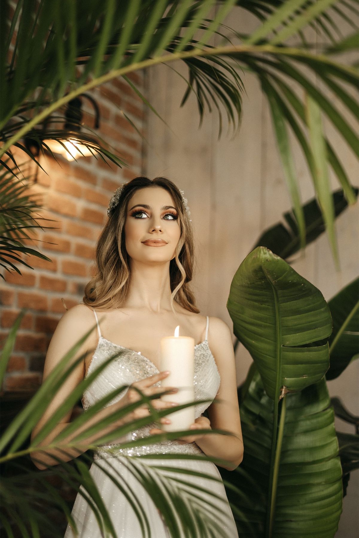 Bride standing among tropical leaves