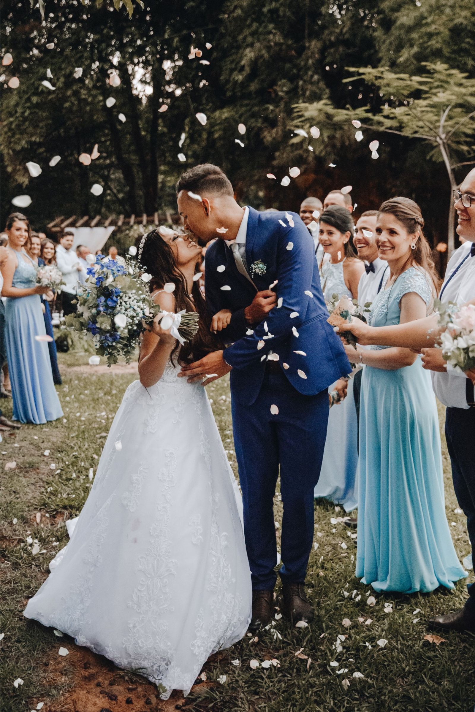 Newlyweds kissing as guests throw confetti