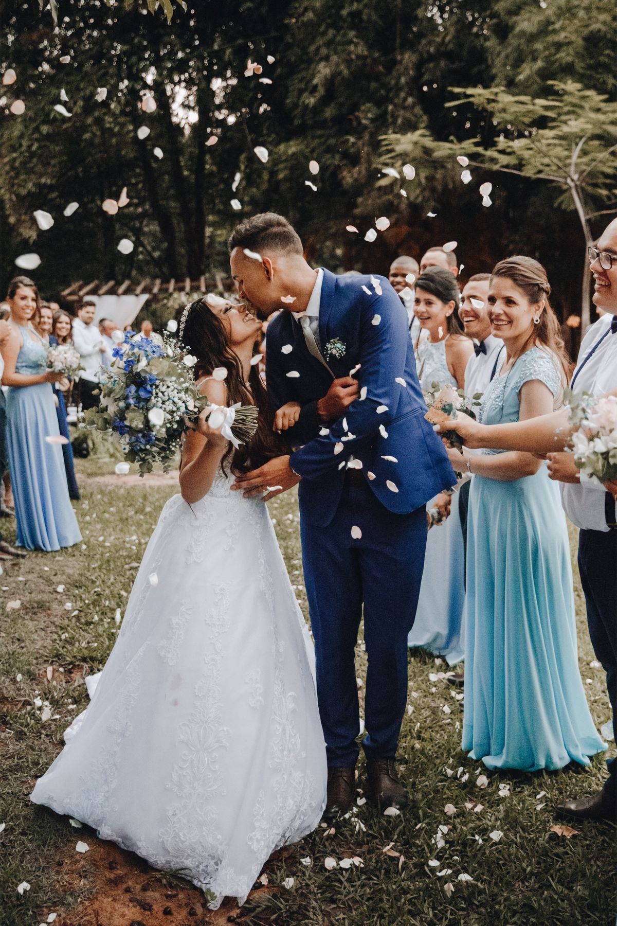 Newlyweds kissing as guests throw confetti