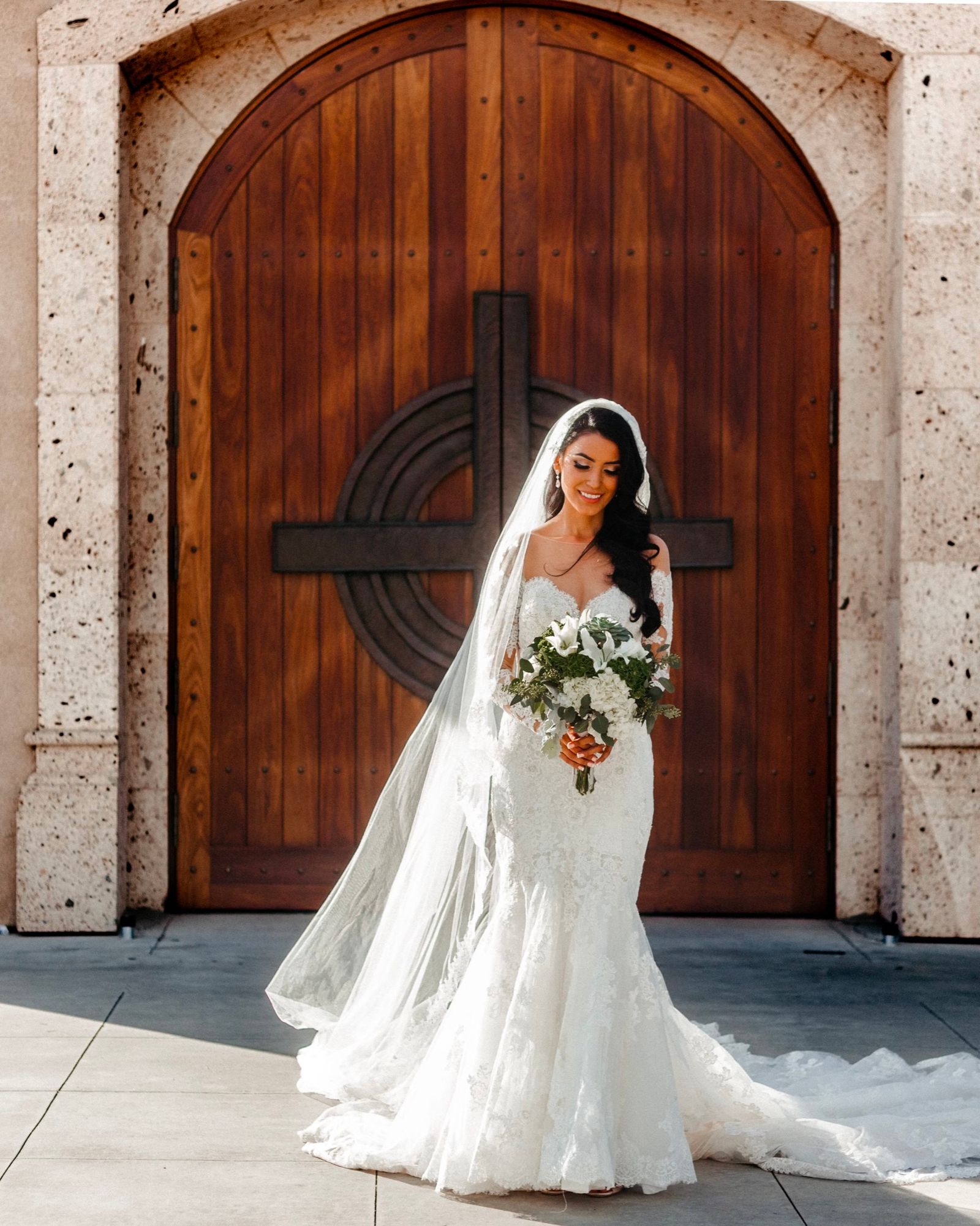 Bride standing in front of a carved wooden door