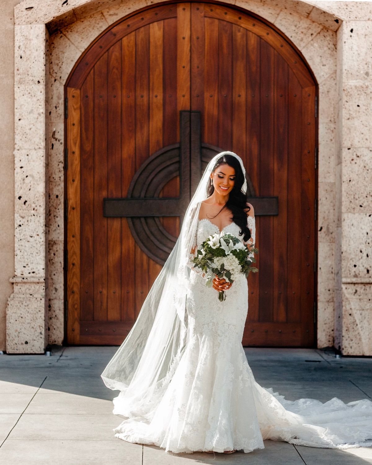Bride standing in front of a carved wooden door