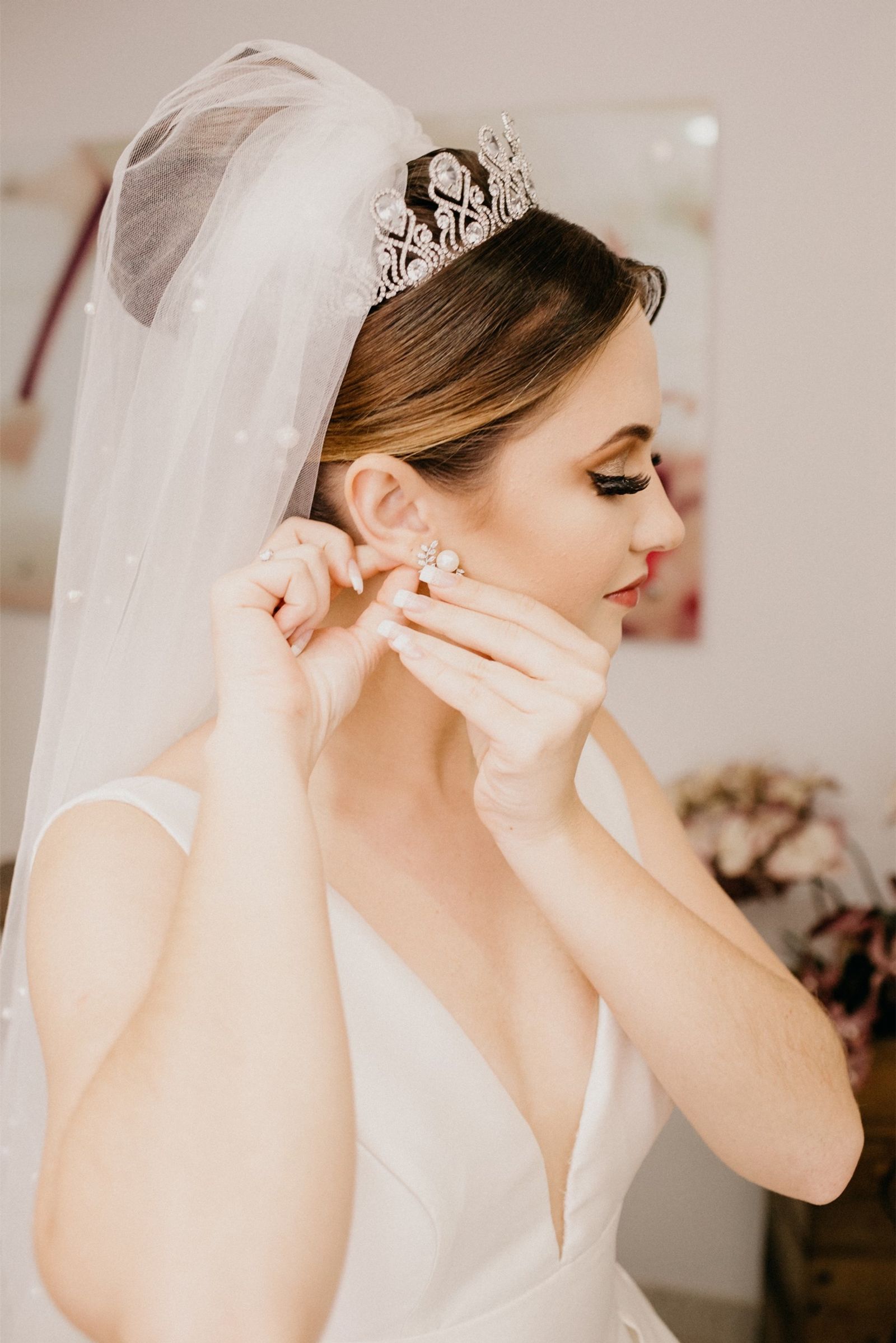 Bride fastening an earring before the ceremony