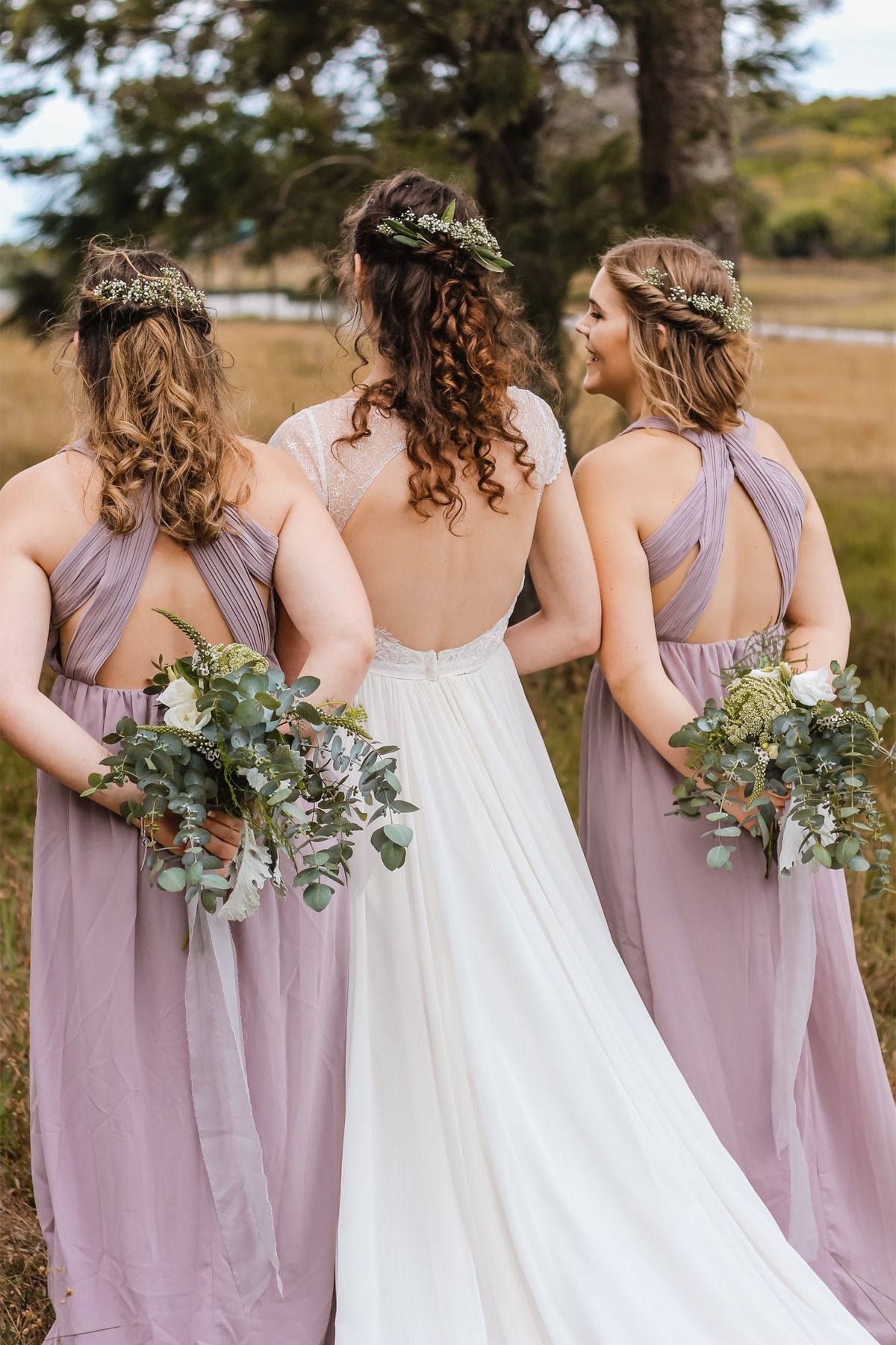 Bridesmaids in matching dresses holding bouquets