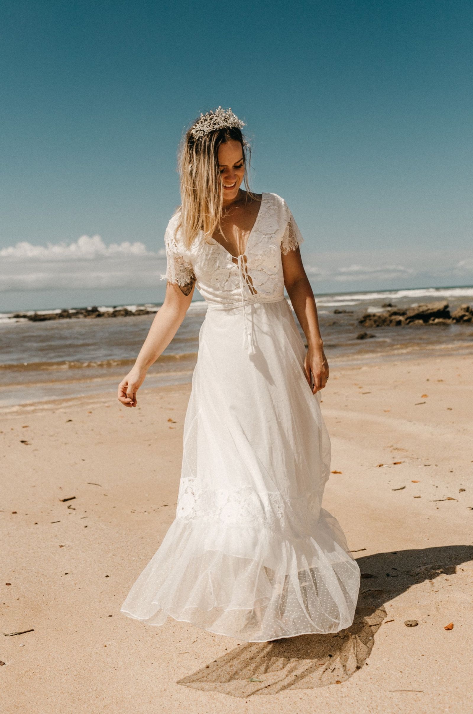 Bride walking along the beach in a long white dress