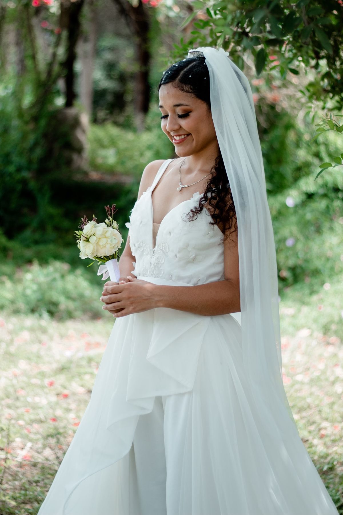 Bride in a V-neck gown and veil outdoors