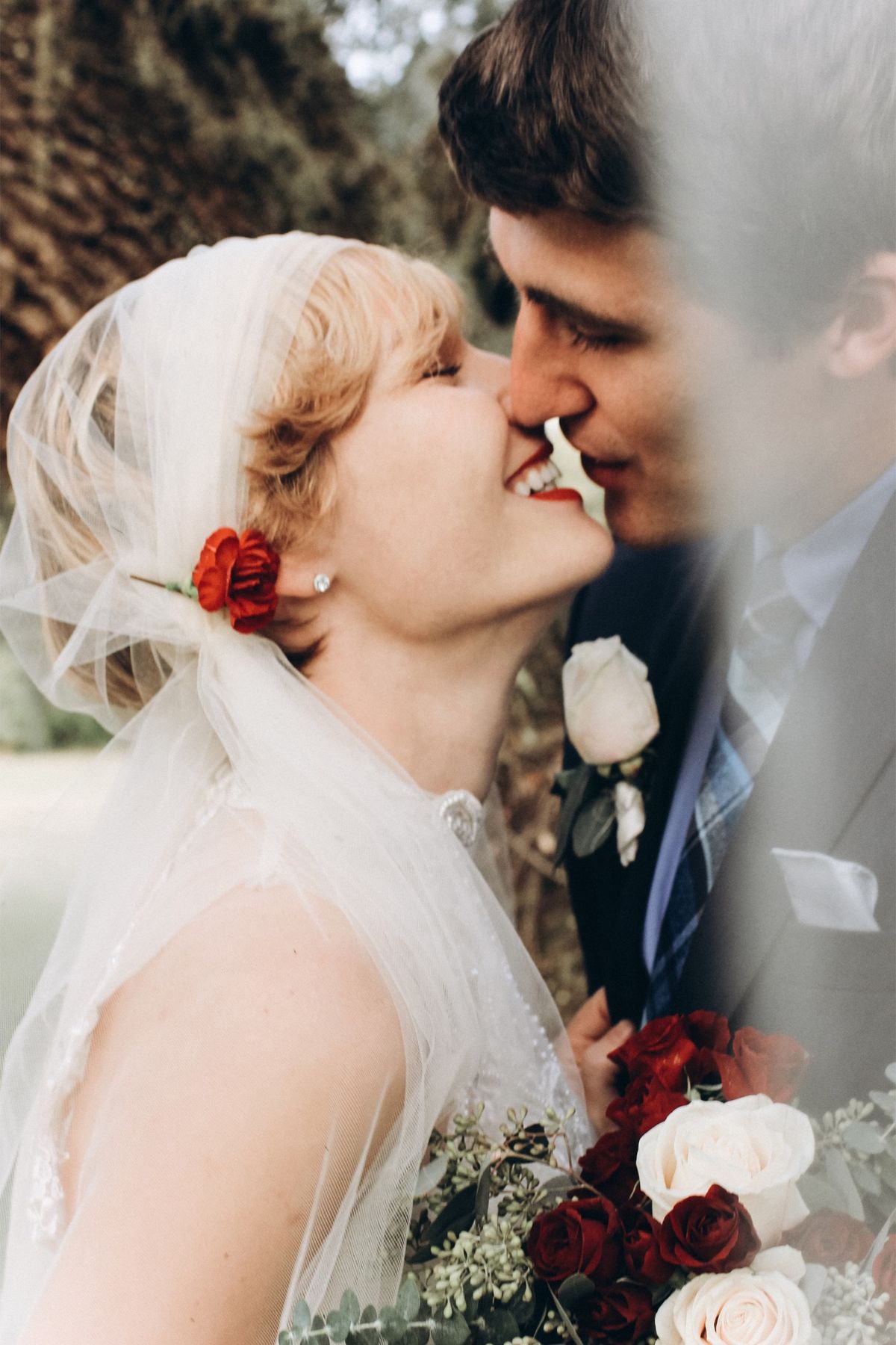 Bride in a veil kissing her groom