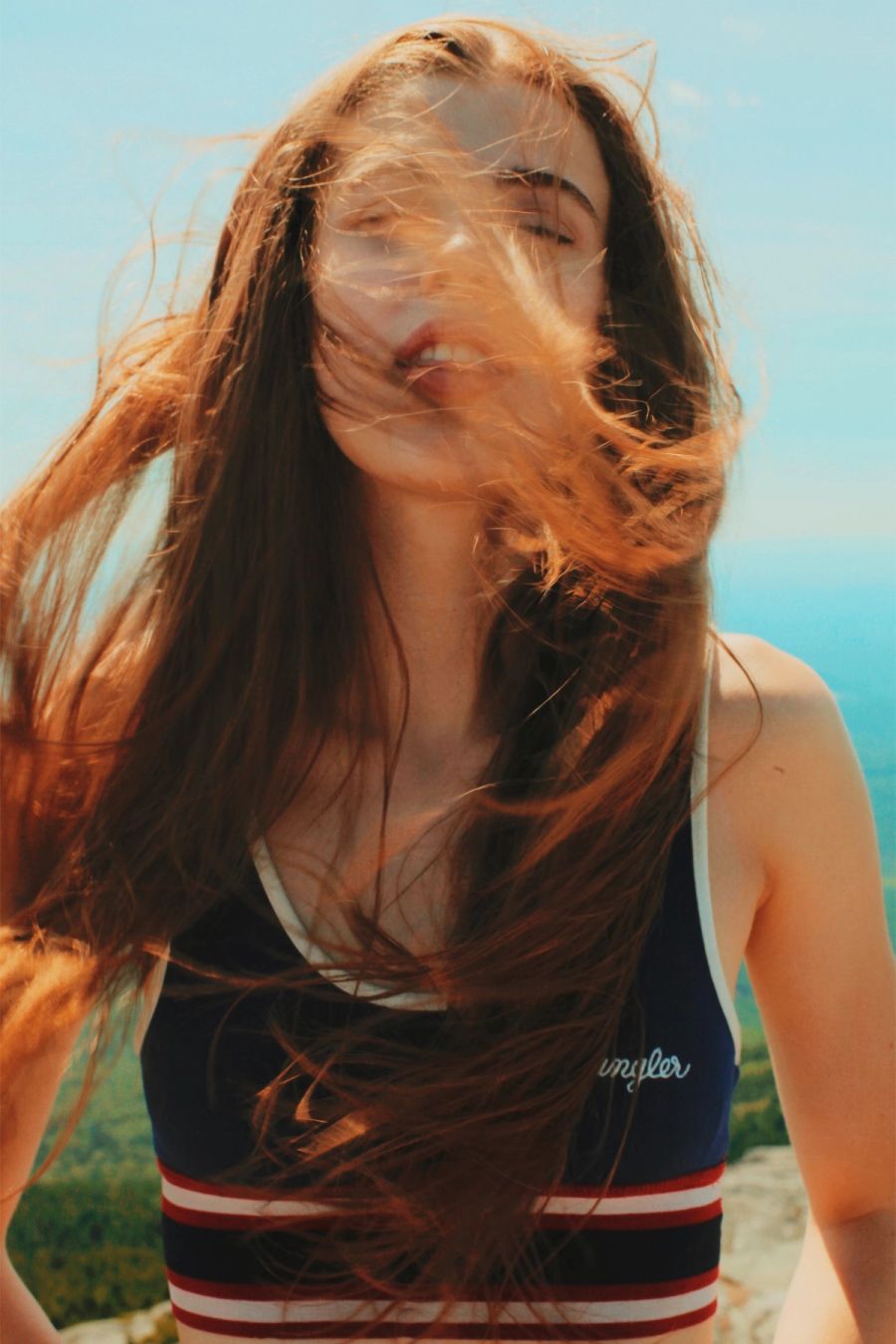 Portrait of Maya Laurent, her hair blowing in the sea breeze