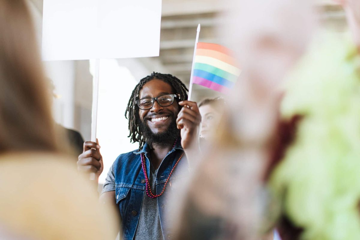 happy-person-waving-lgbtq-community-flag-in-office