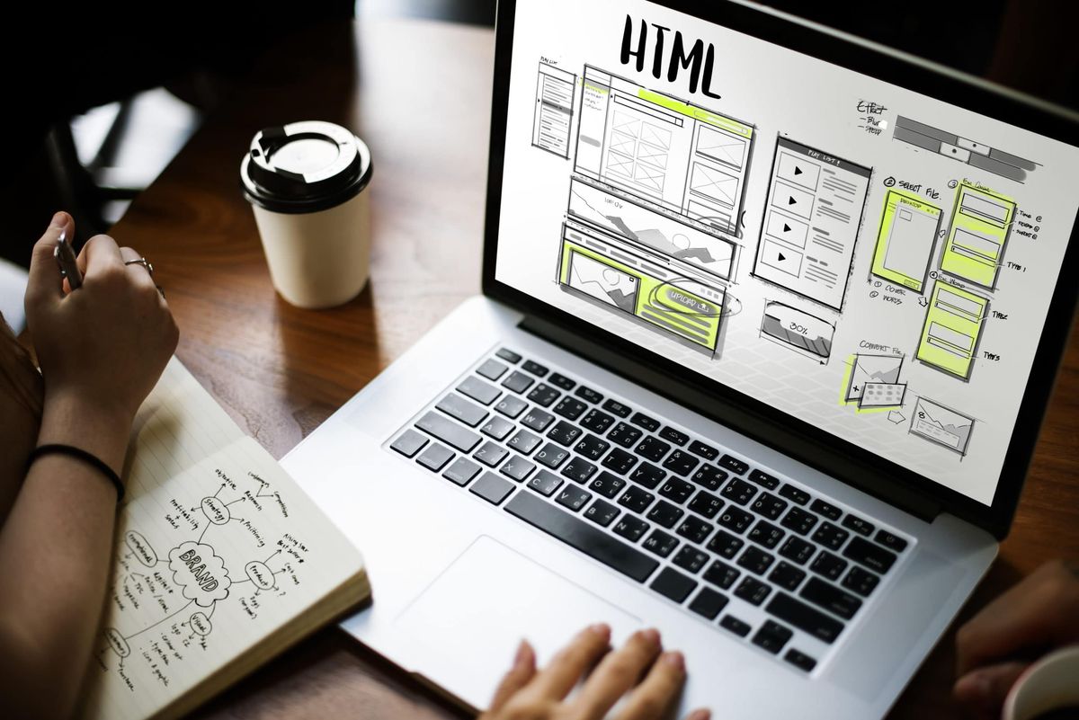 laptop-on-desk-html-written-on-screen