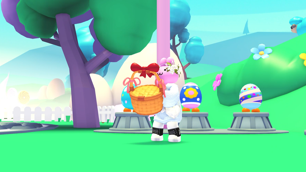 A pink bunny avatar stands holding a wicker easter basket with red and pink bows. Behind them stands three brightly pattenered aggs with feet! The background is lush green hills and flowers, giant eggs and a white picket fence. A tall tree stands on the left of the image.