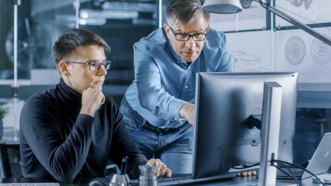 A data science leader works with a younger colleague