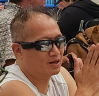 Clapping community member wearing sunglasses and a white shirt.