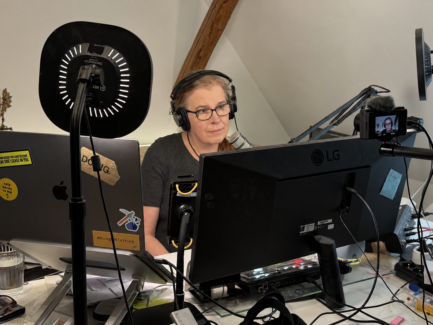 Johanna at her desk with headphones and a microphone for an online conversation