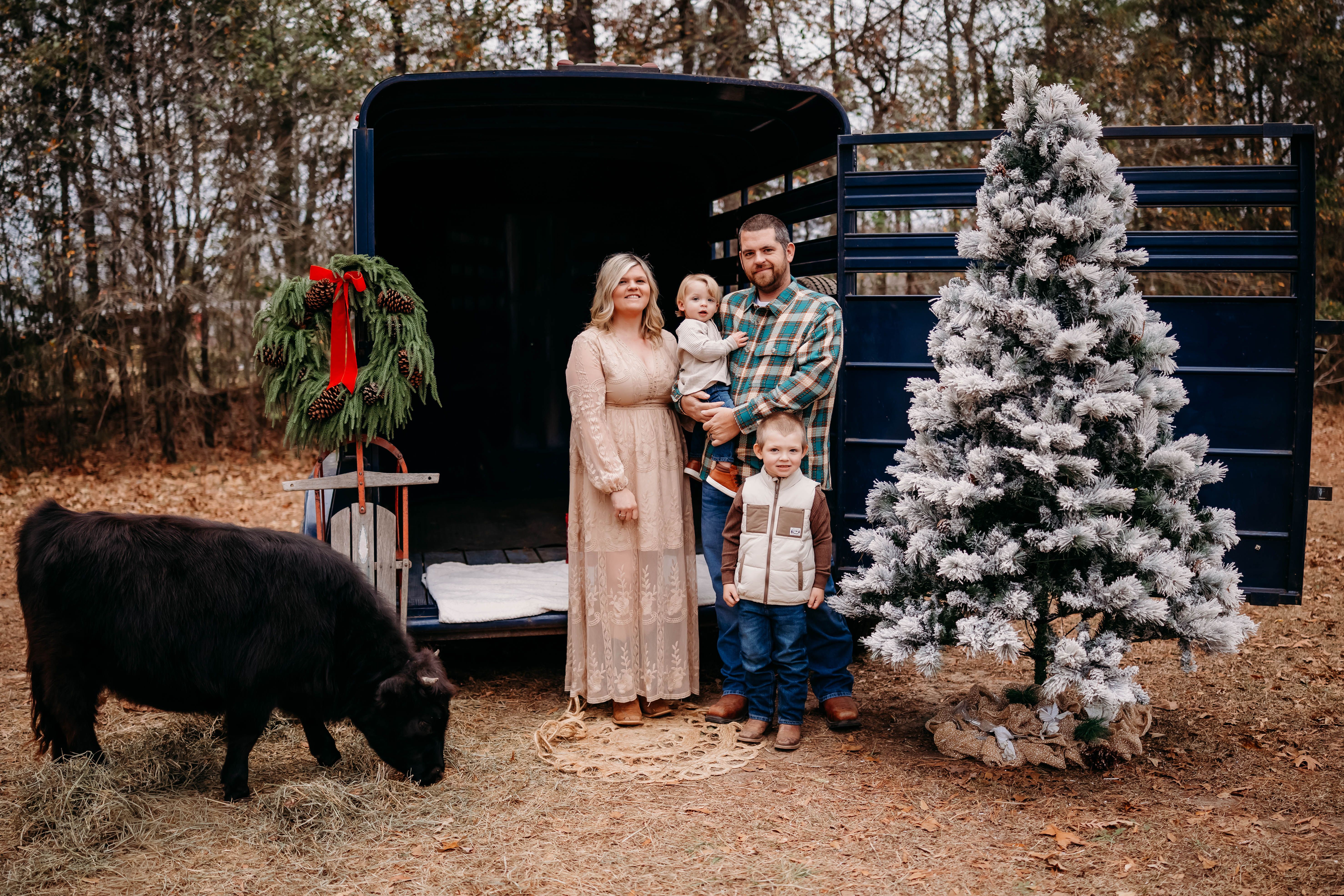 Lauren Strickland and family by a Christmas tree on a farm