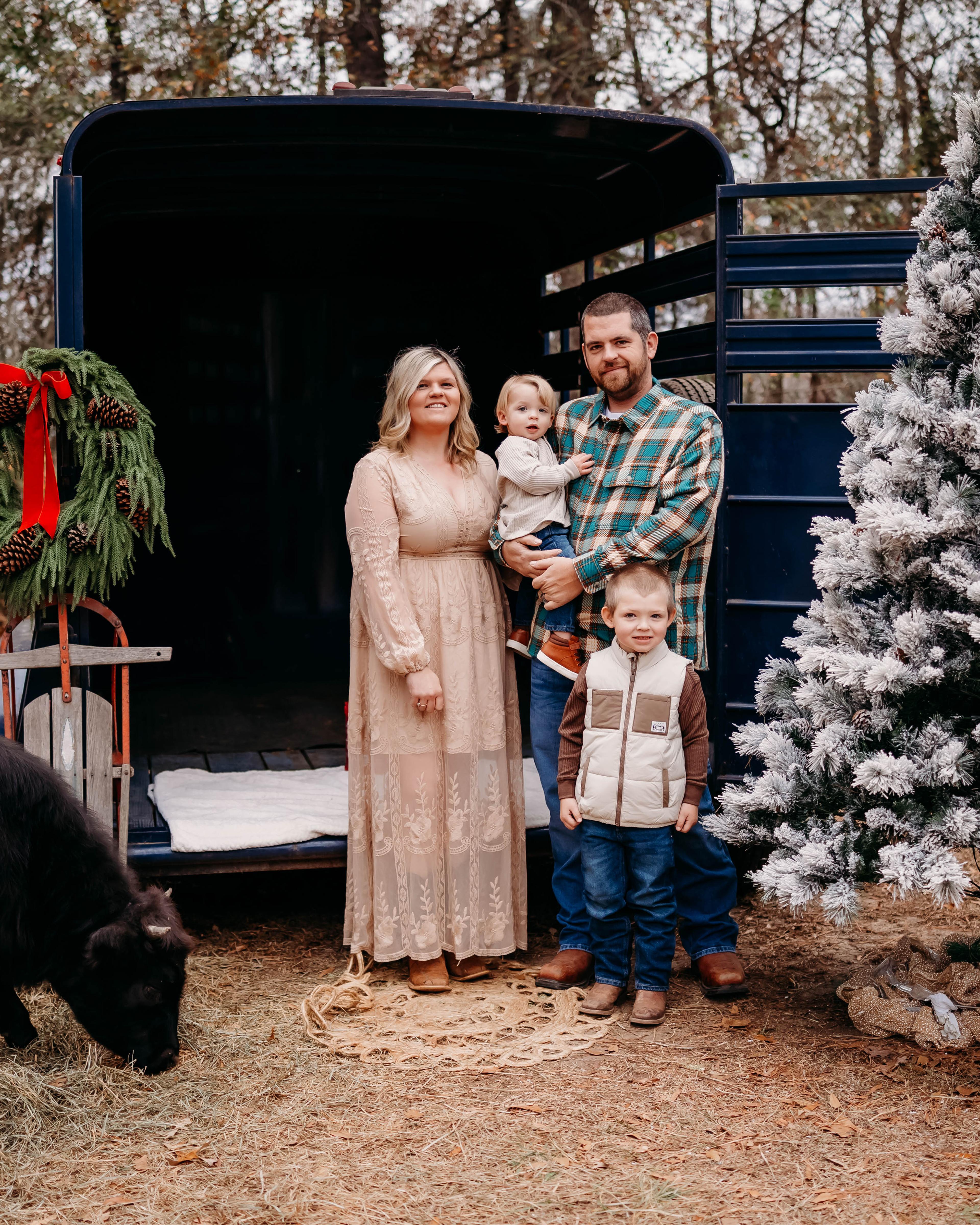 Lauren Strickland and family by a Christmas tree on a farm