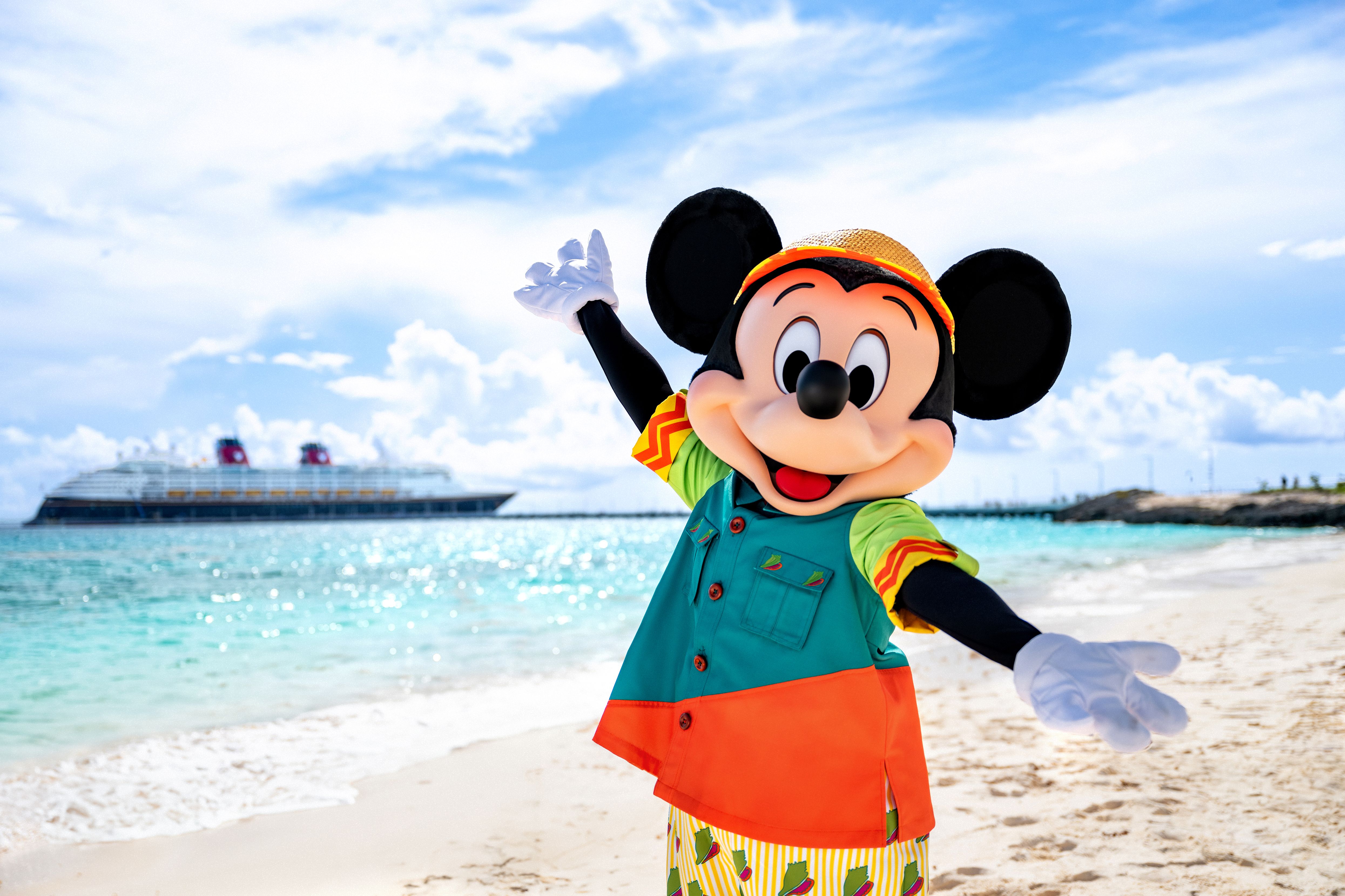 A Disney Cruise Line ship departing port at sunset