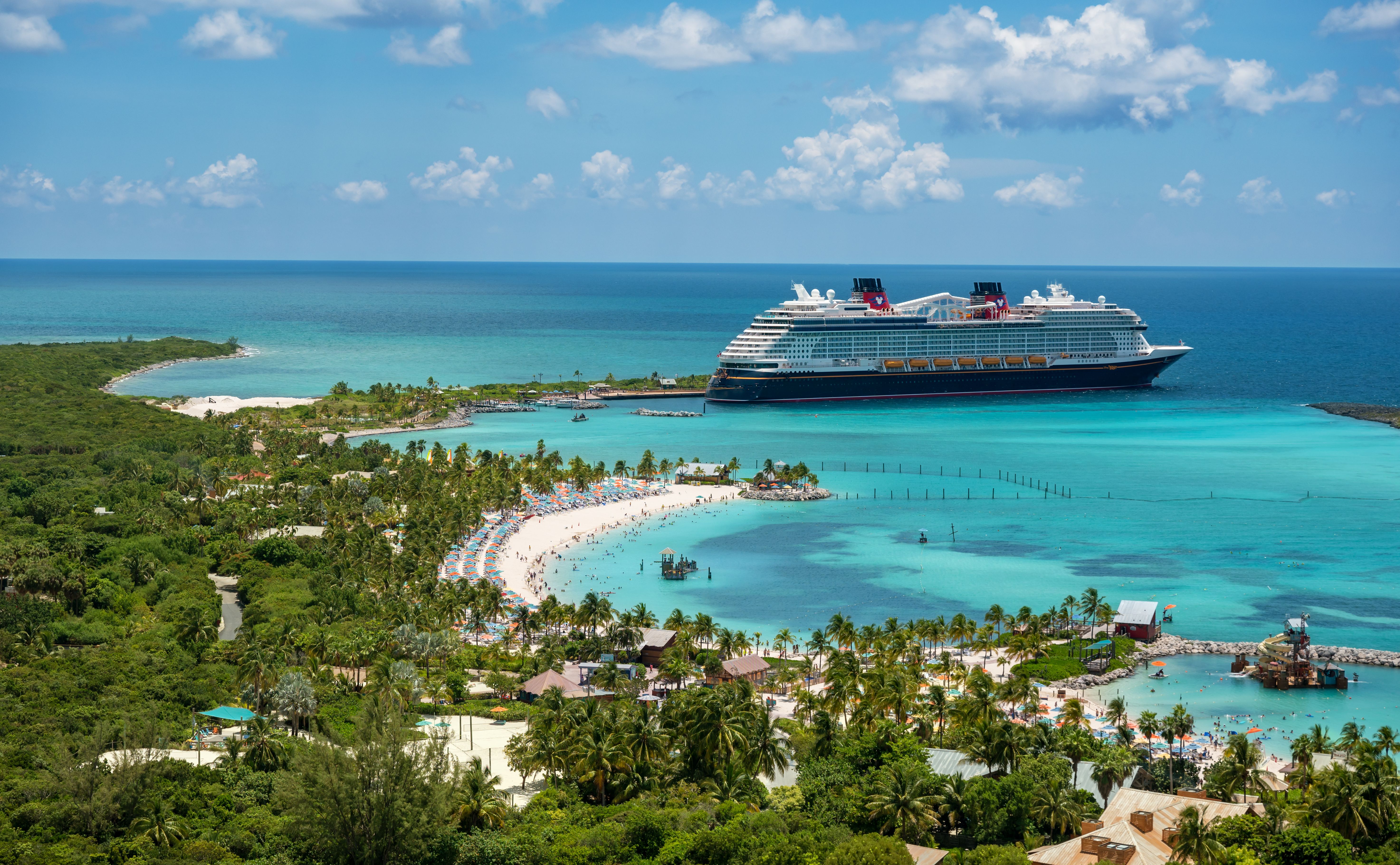 Bird's eye view of turquoise waters and a cruise ship at an island port