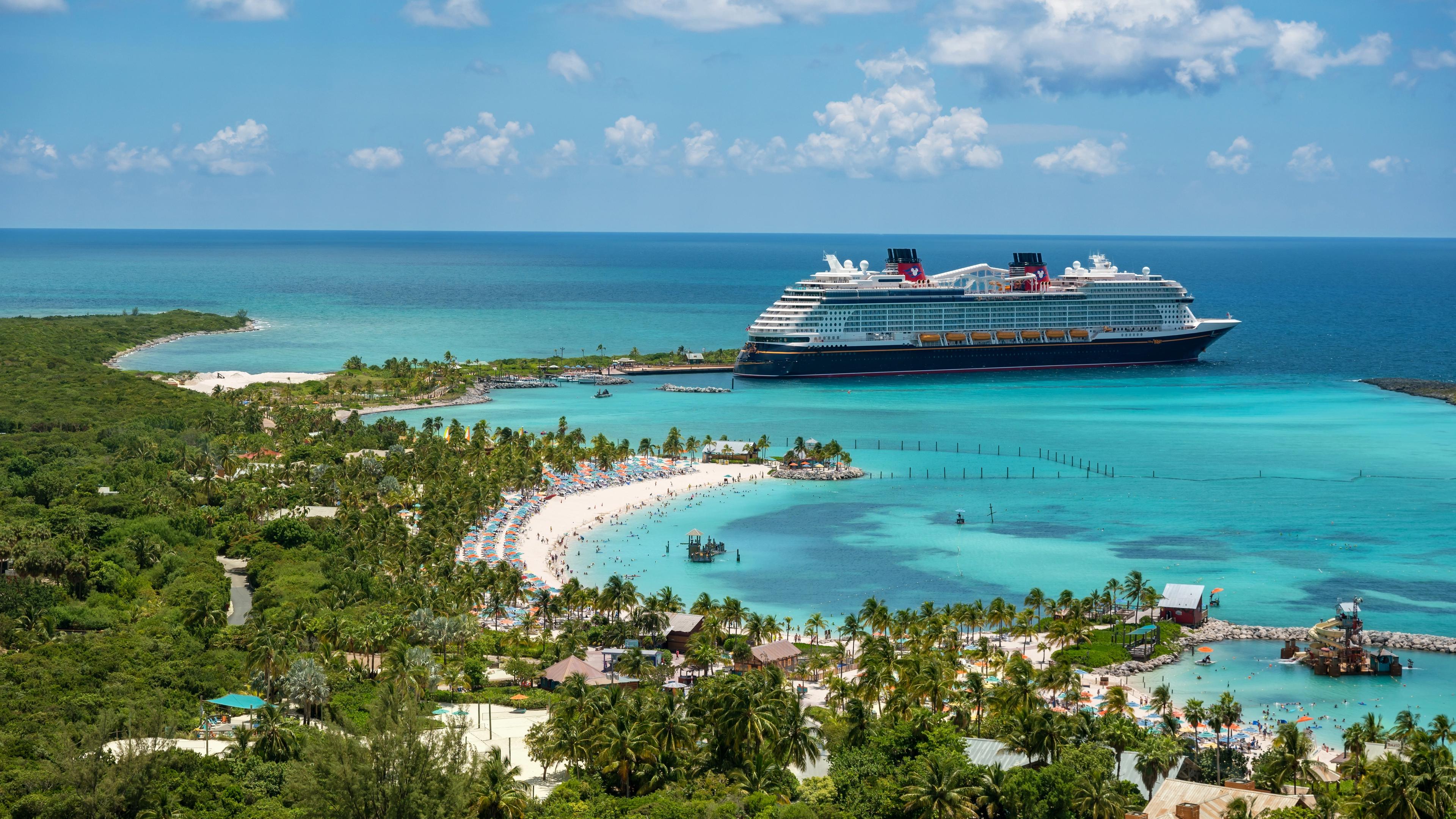 Bird's eye view of turquoise waters and a cruise ship at an island port