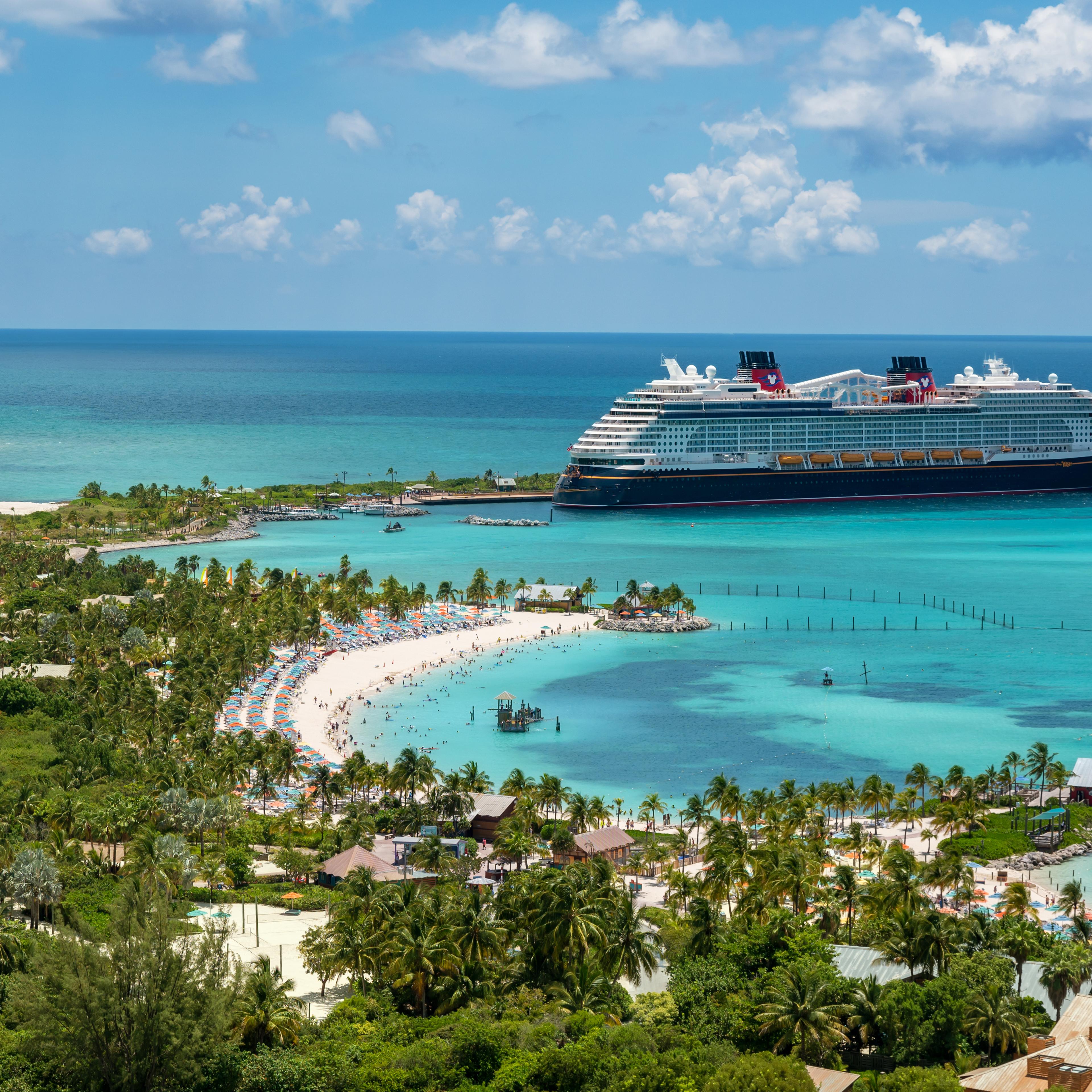 Bird's eye view of turquoise waters and a cruise ship at an island port