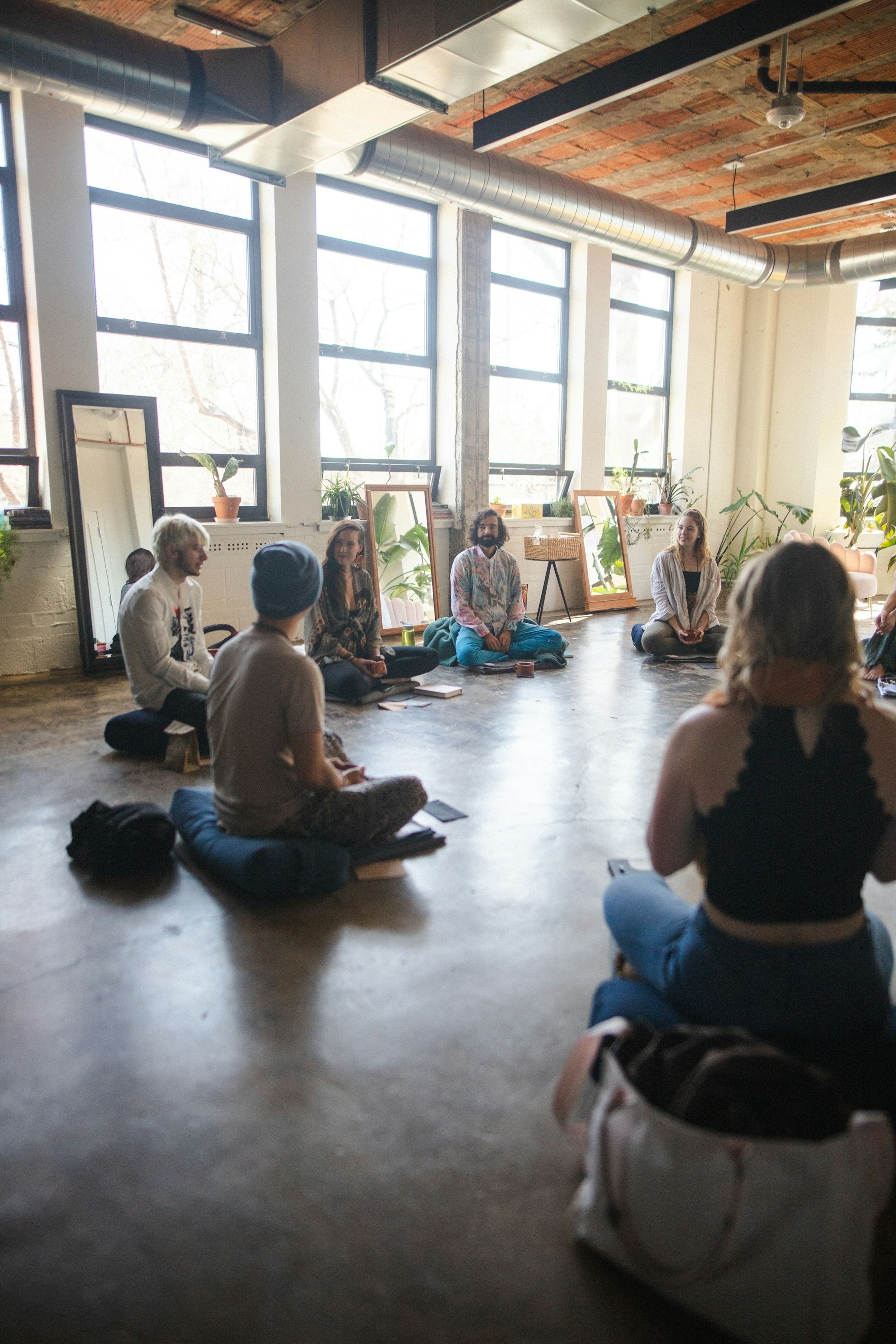 A group sitting on the floor of a sunny studio