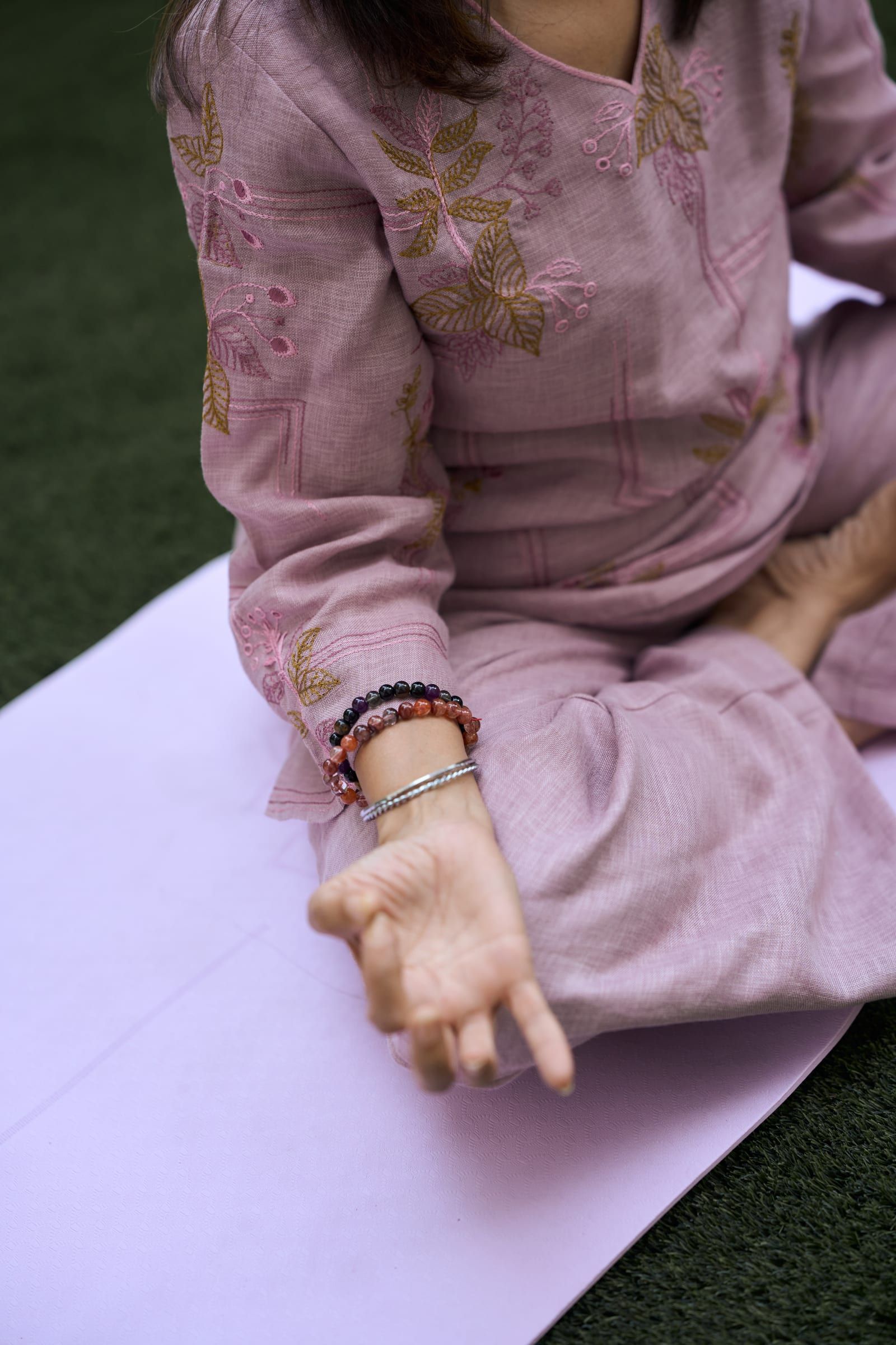 Close-up of Manisha's hand resting in a mudra during meditation