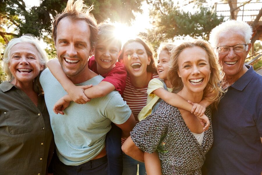 Outdoor portrait of multi-generational family with great teeth and smiles