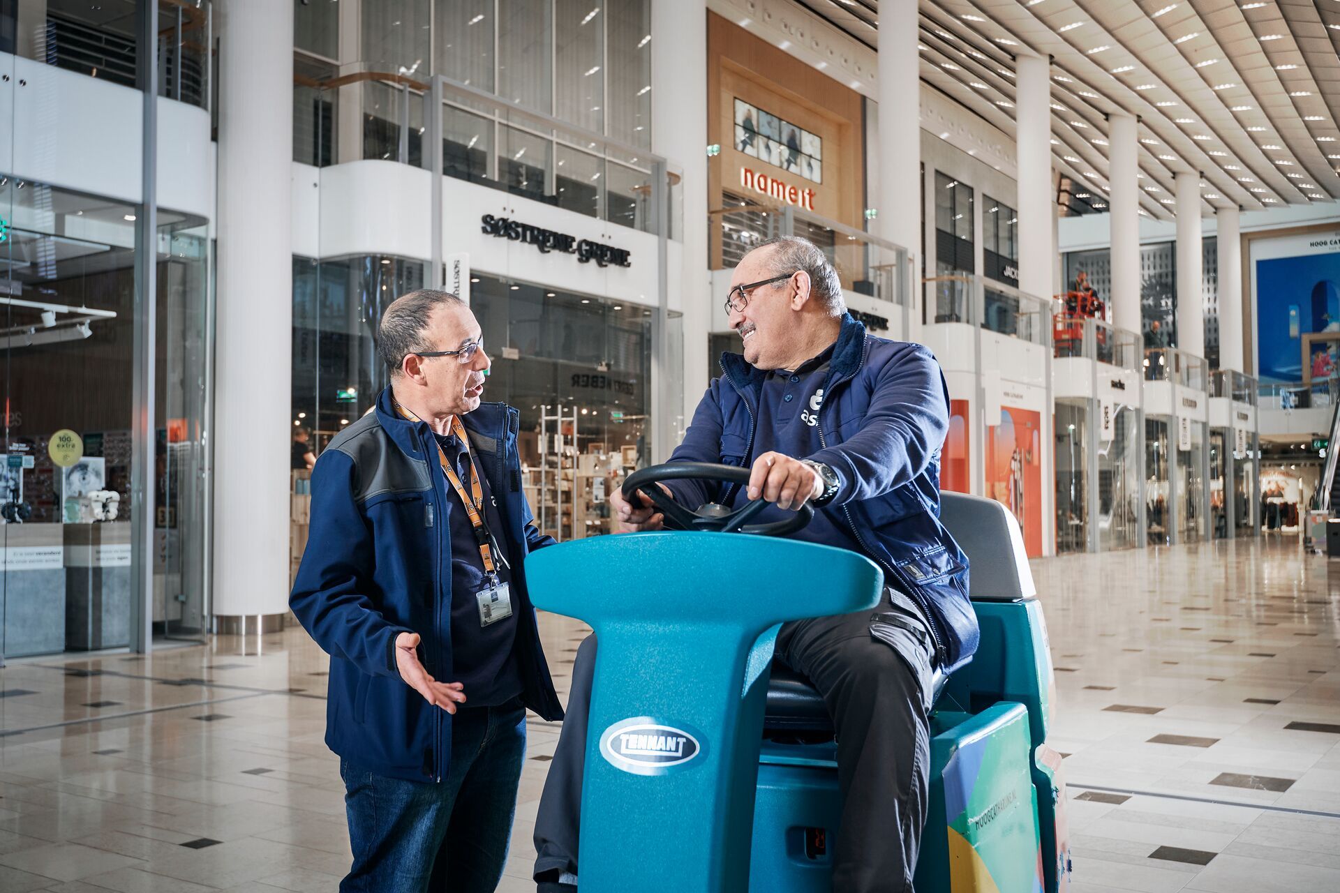 Medewerkers praten in winkelcentrum