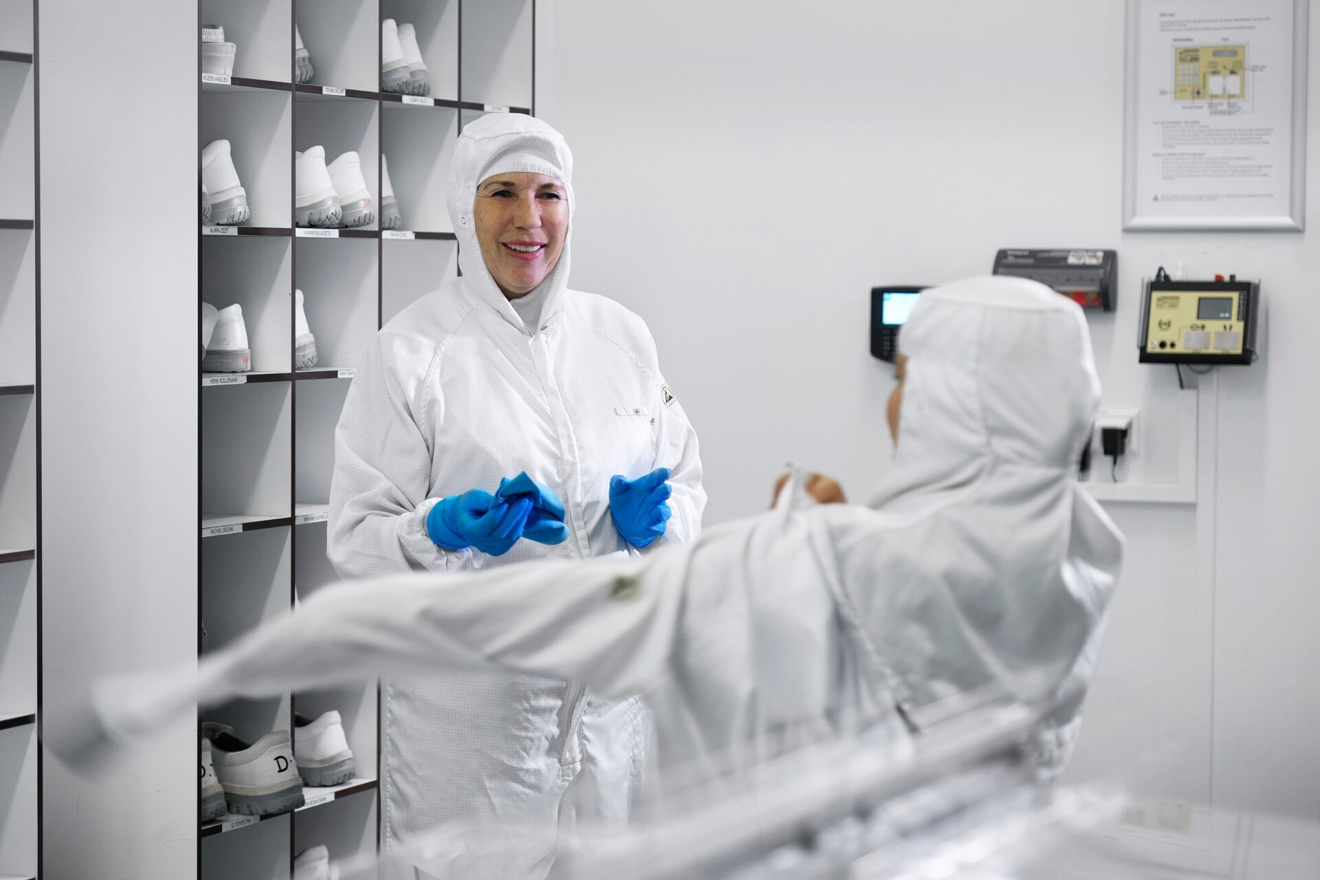 schoonmaakmedewerkers van Asito kleding zich om voor het werk in de cleanroom