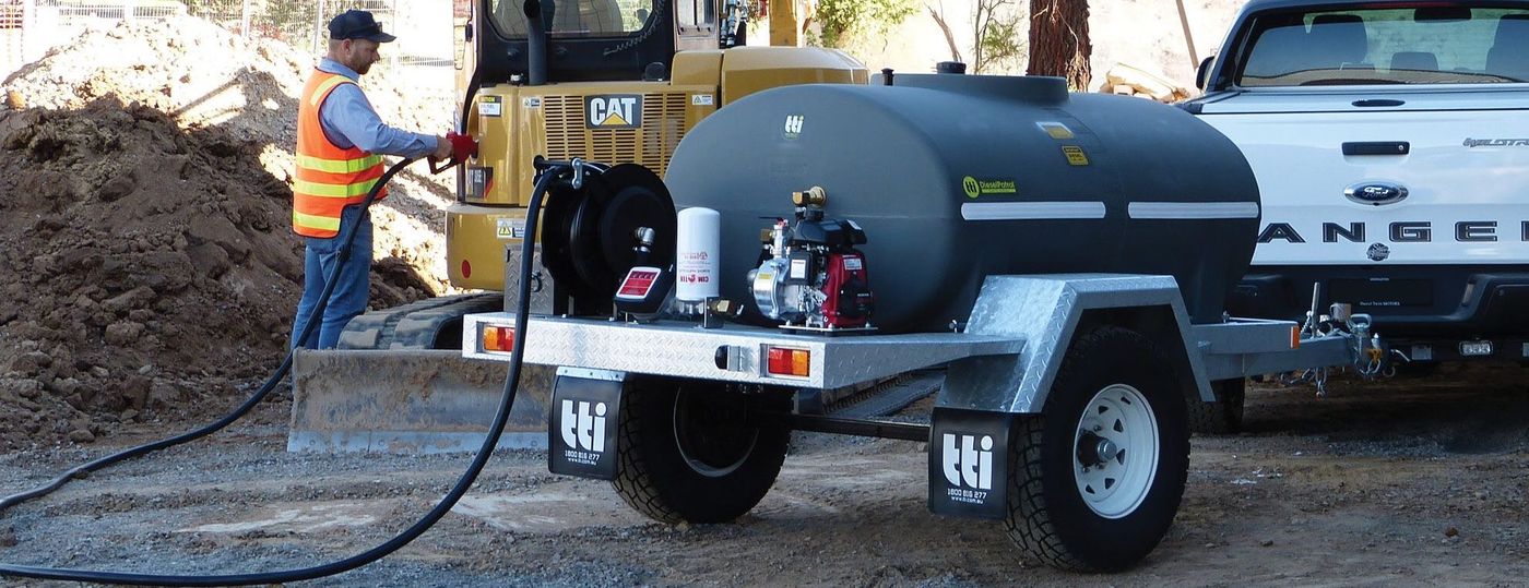 A portable diesel tank on a trailer beside an excavator