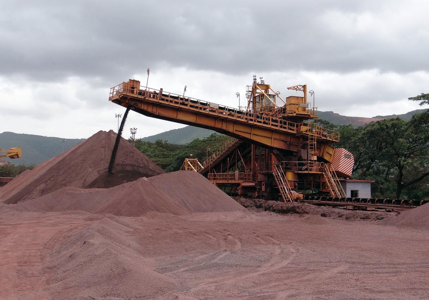 A stacker building a stockpile of crushed ore beside a conveyor