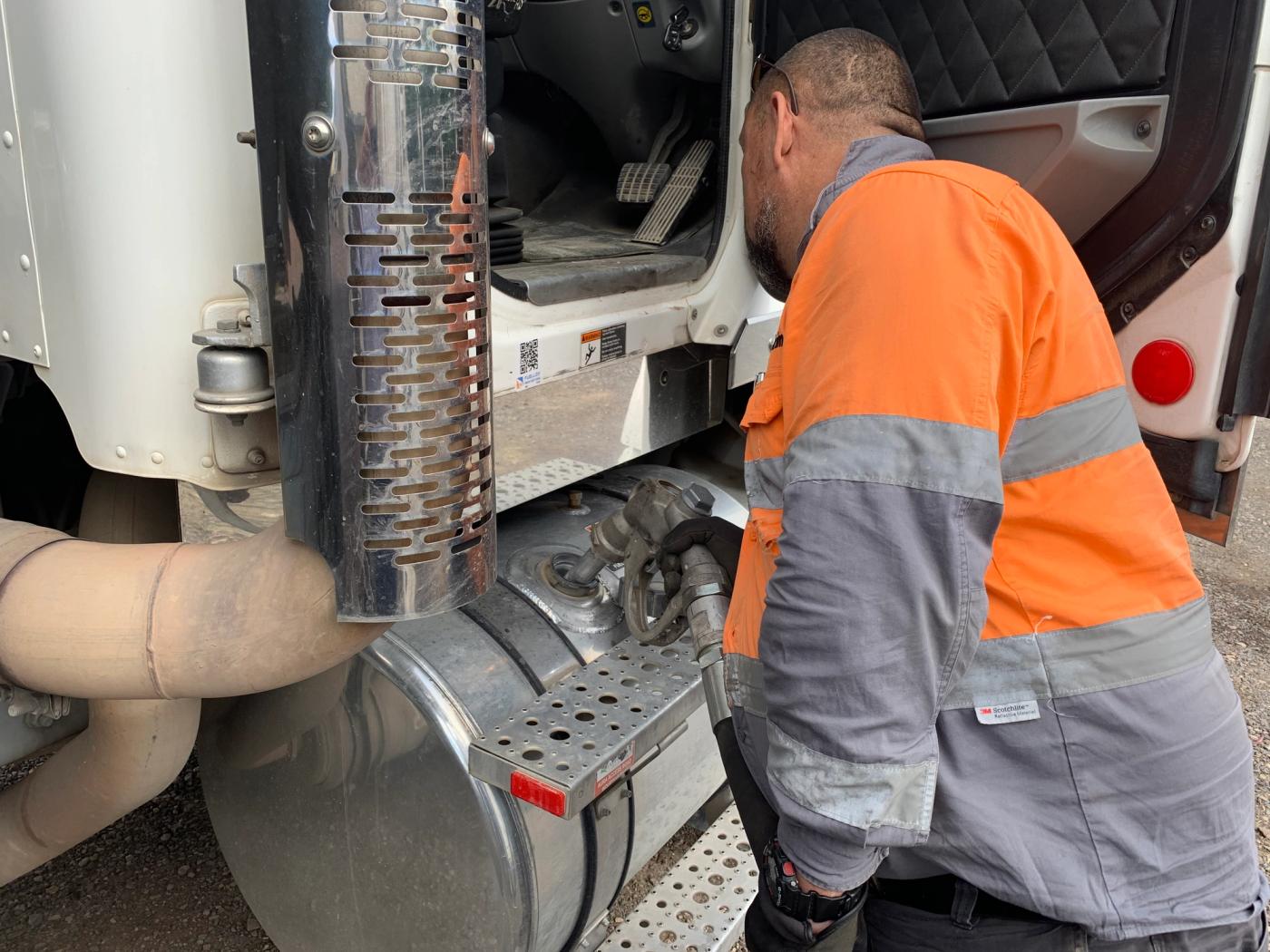 An operator refuelling a heavy truck