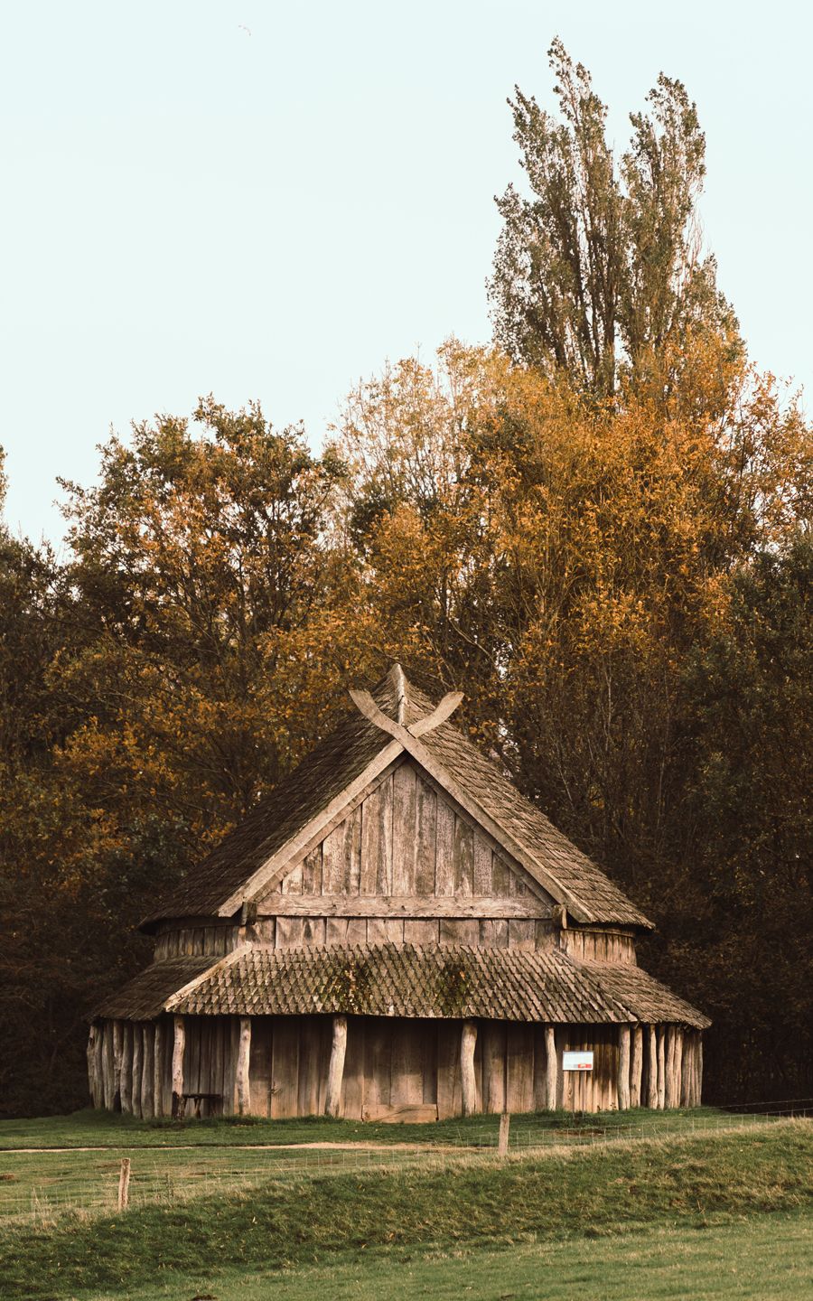 Fotografi af langhusets ene gavl med trætoppe i baggrunden
