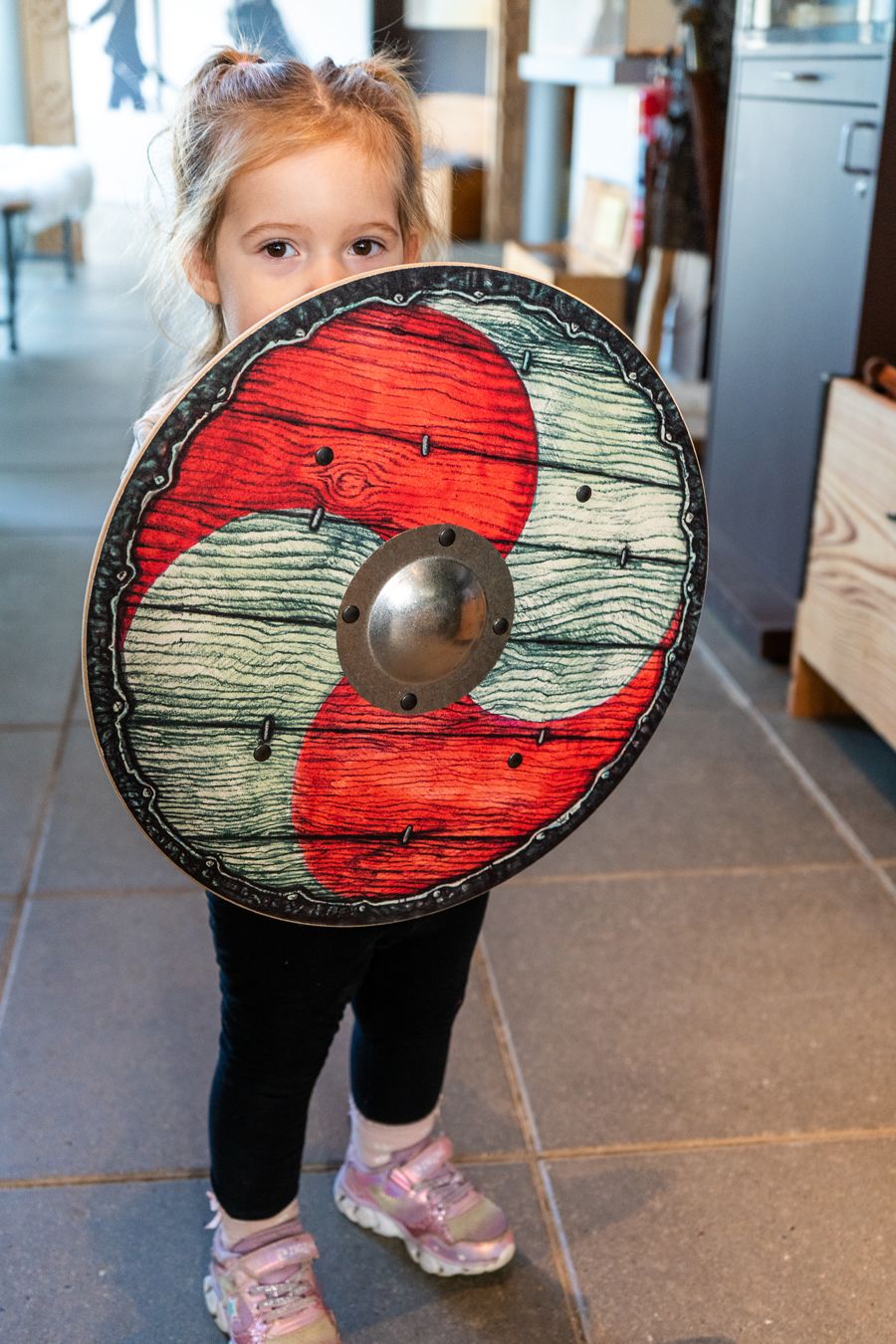 Pige holder et vikingeskjold til at lege med, købt i butikken