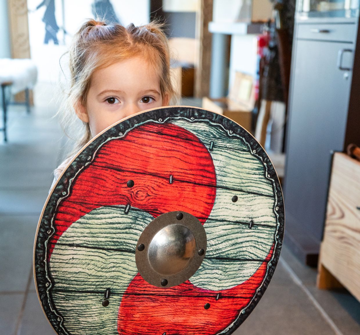Pige holder et vikingeskjold til at lege med, købt i butikken