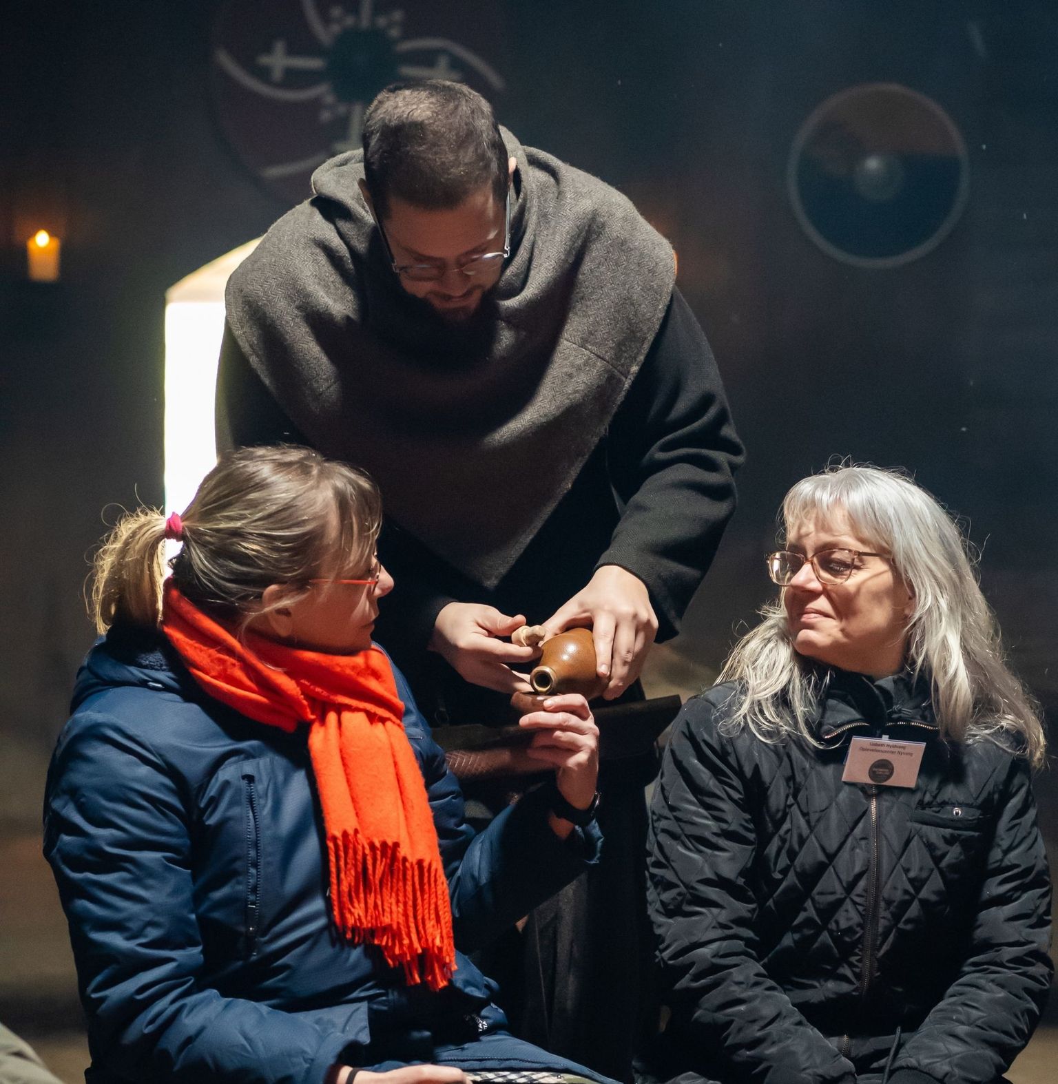 Gæster får hældt mjød i koppen ved bålet af mand i vikingedragt