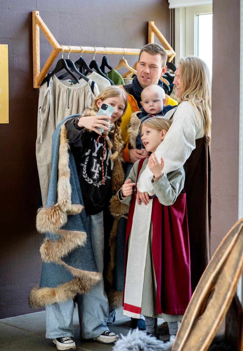 Familie tager selfie iført vikingetøj fra museets udklædningsstation på Trelleborg.