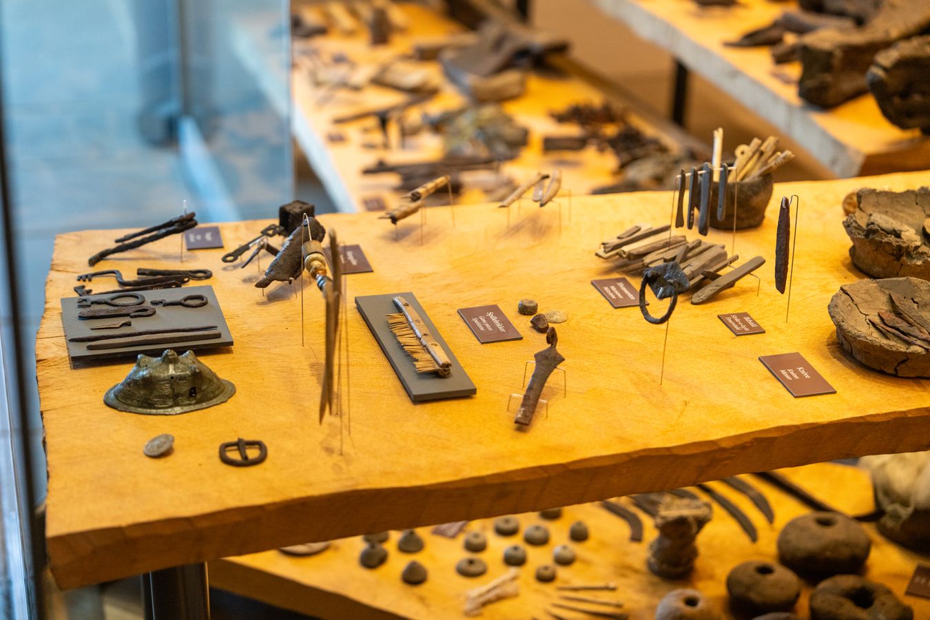 Udstillingsmontre med arkæologiske vikingefund – nøgler, kamme, redskaber og dagligdags genstande – på Trelleborgs museum.