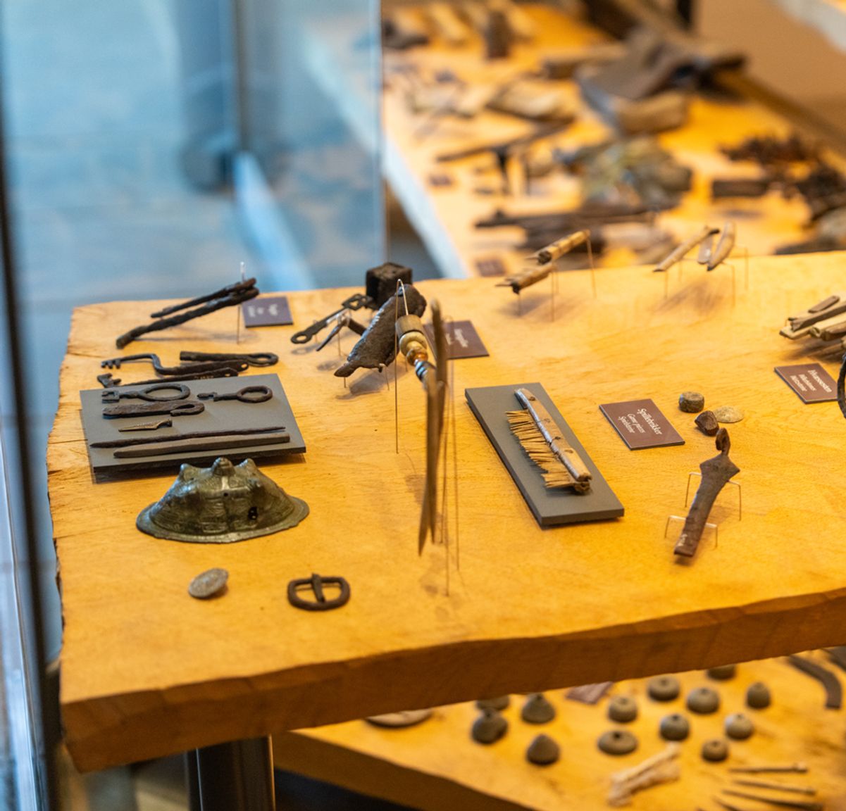 Udstillingsmontre med arkæologiske vikingefund – nøgler, kamme, redskaber og dagligdags genstande – på Trelleborgs museum.