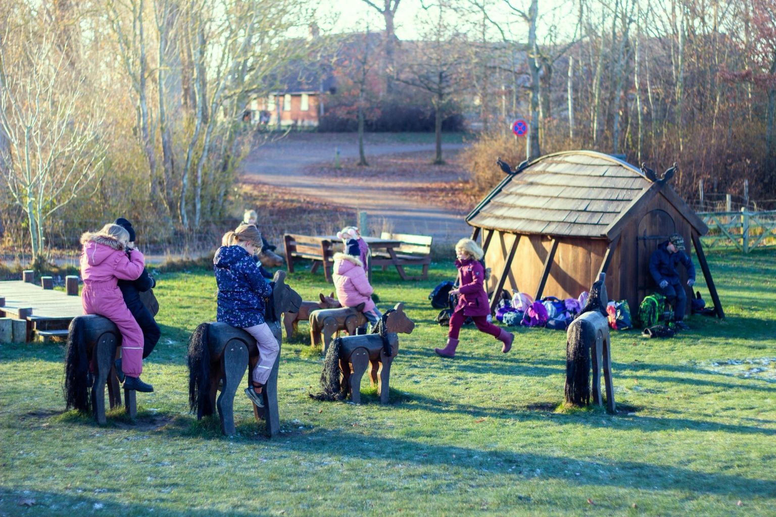 Children on the playground with the longhouse in the background