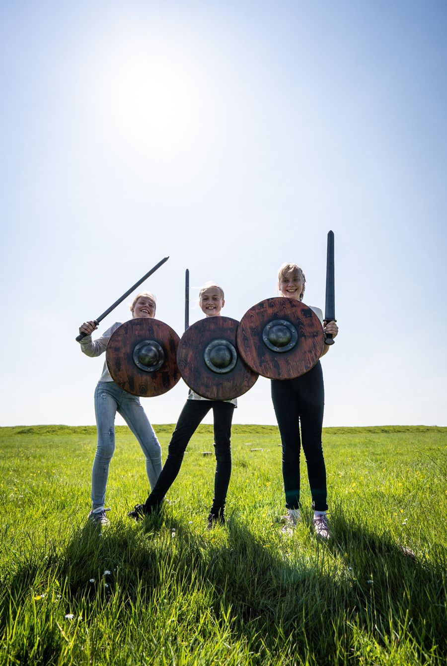 Tre elever holder skjolde og sværd inspireret af vikingetiden