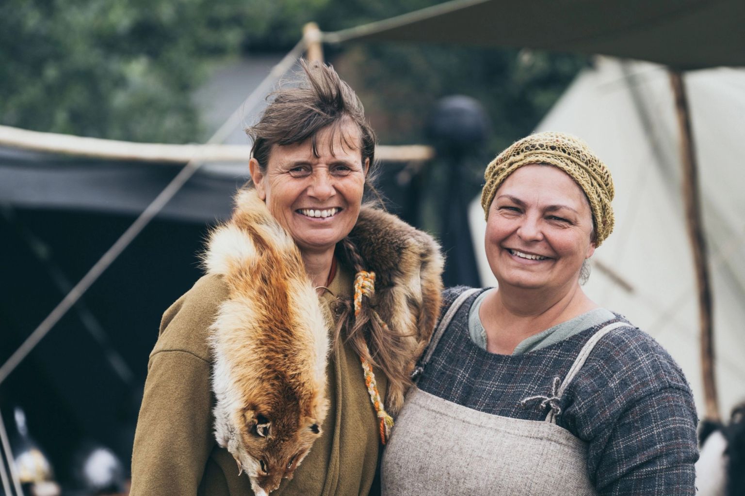 Two smiling female volunteers in Viking clothing