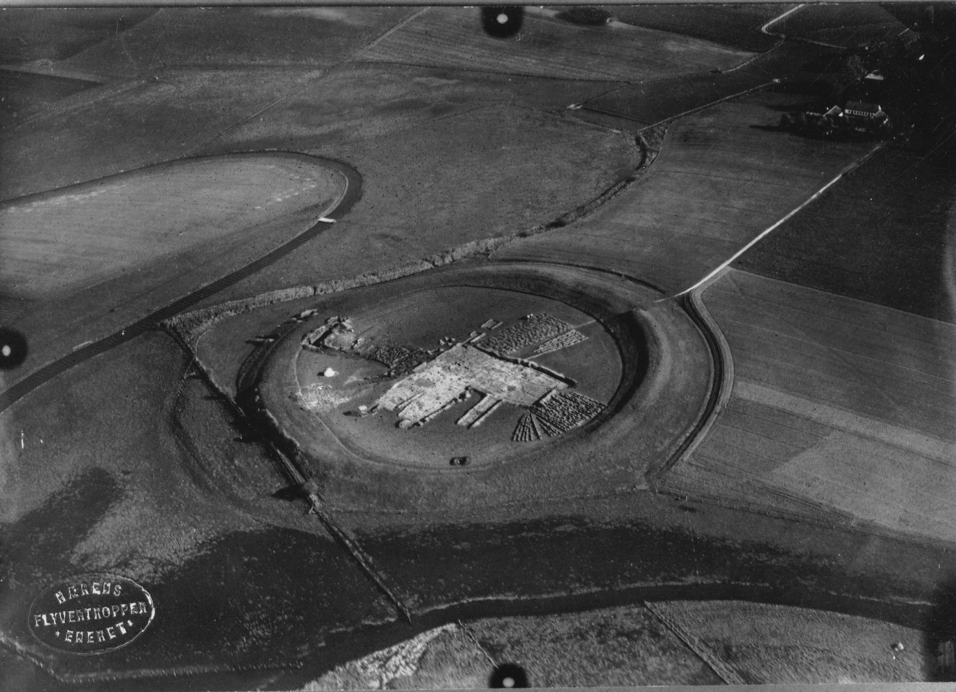 Aerial photograph from the excavation of Viking ring fortress Trelleborg (1934-1942), showing the circular earthwork structure and buildings within the fort.