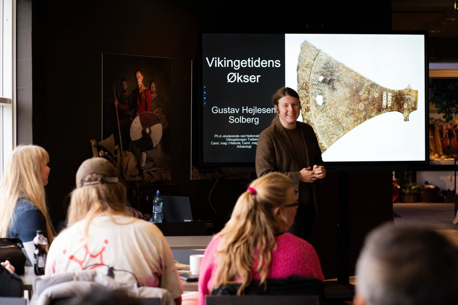 En formidler fortæller publikum om Vikingetidens økser.