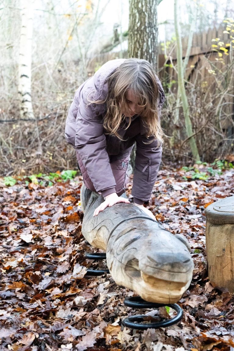 Little girl on balance beam like a worm on the playground