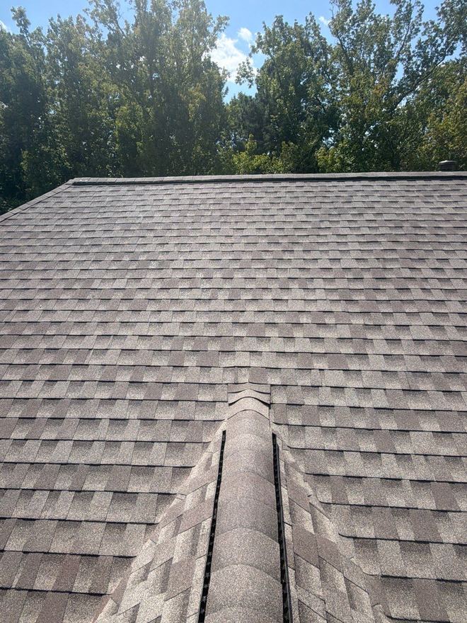 Hip ridge running up to the peak of a newly shingled roof